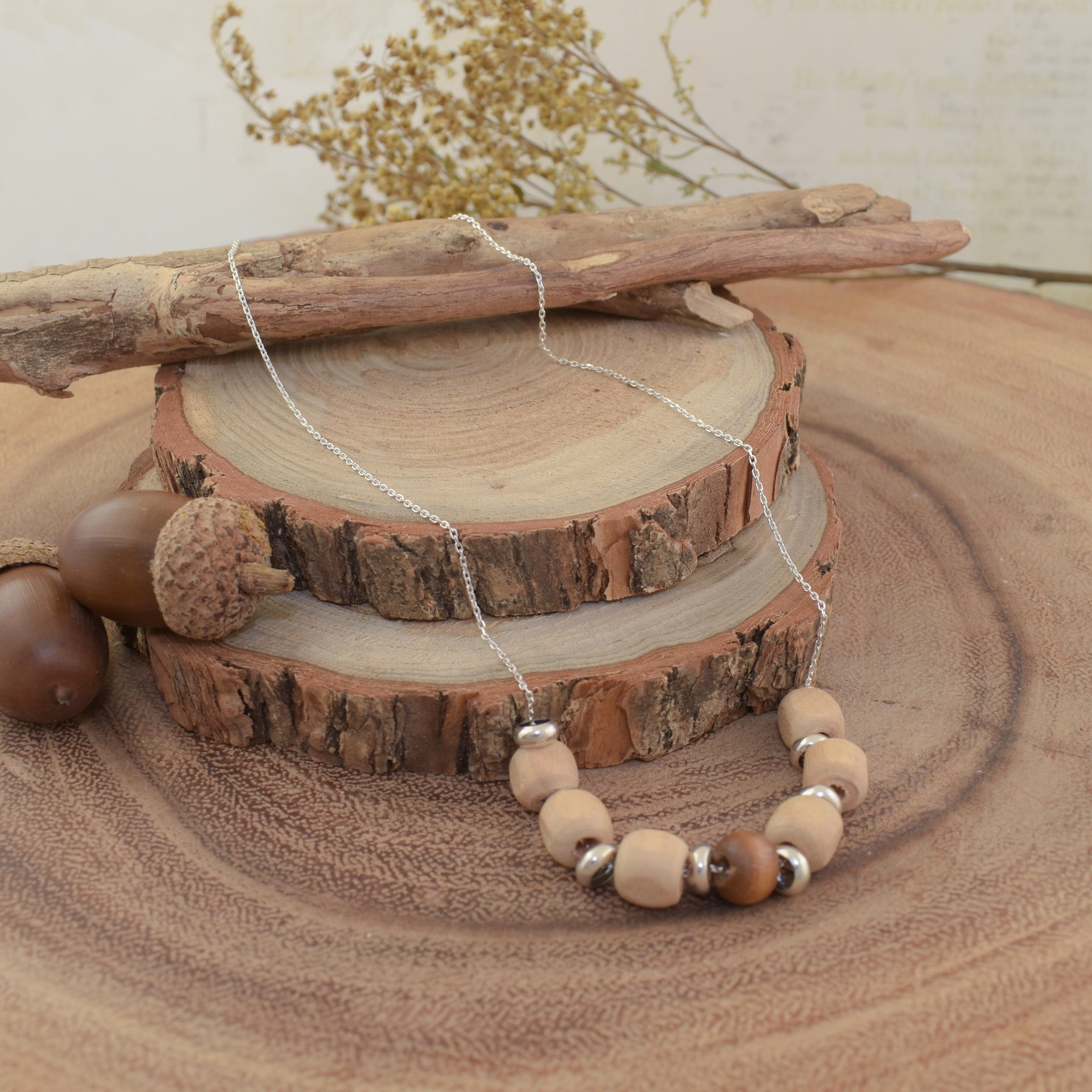A sterling silver necklace with wooden bead accents and silver spacer beads