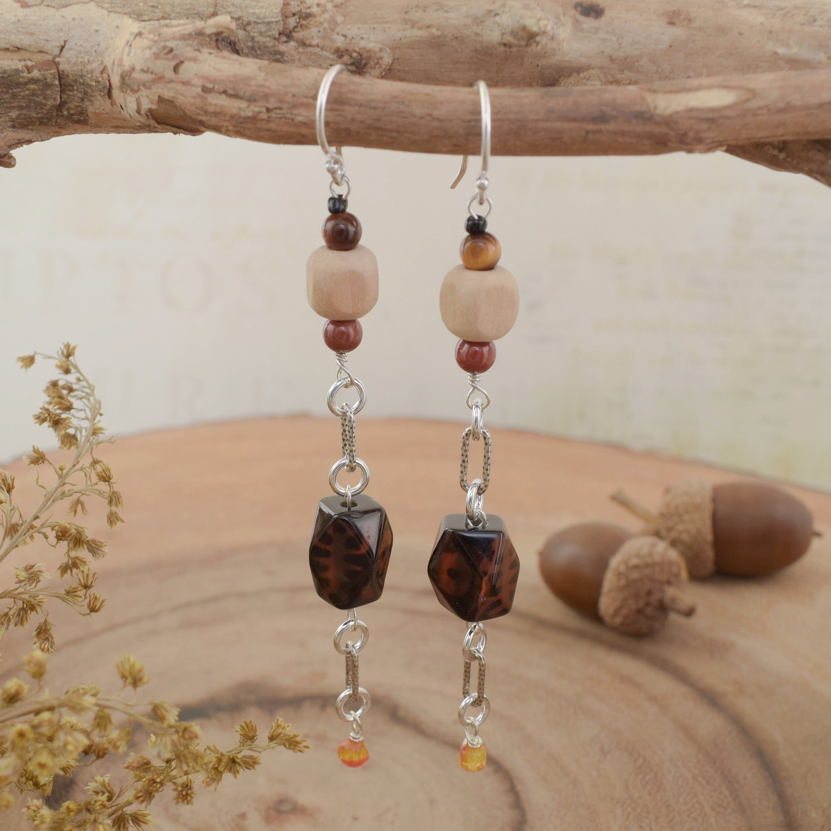 A pair of dangly earrings with sterling silver hooks and multi-colored fall beads