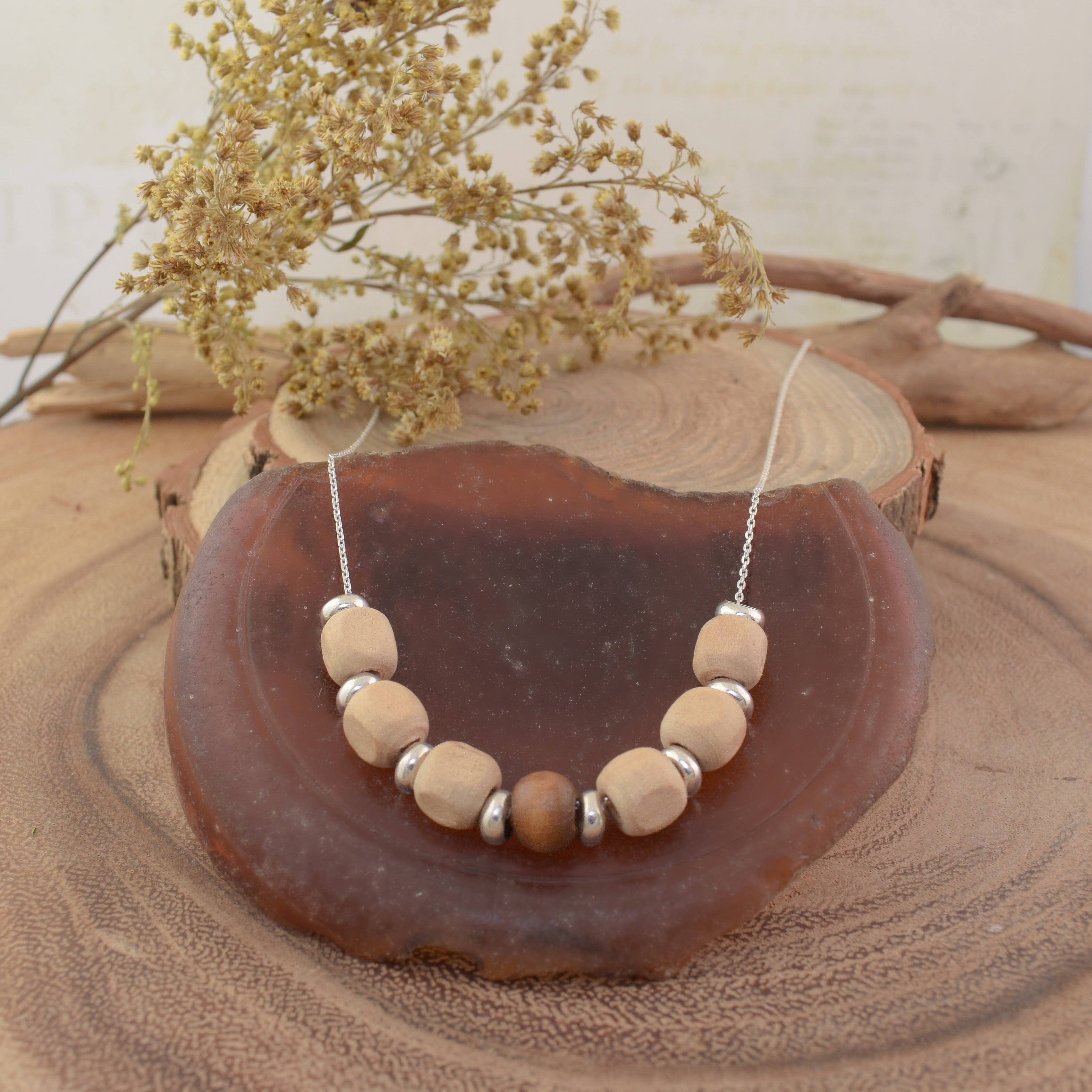 A sterling silver necklace with wooden bead accents and silver spacer beads