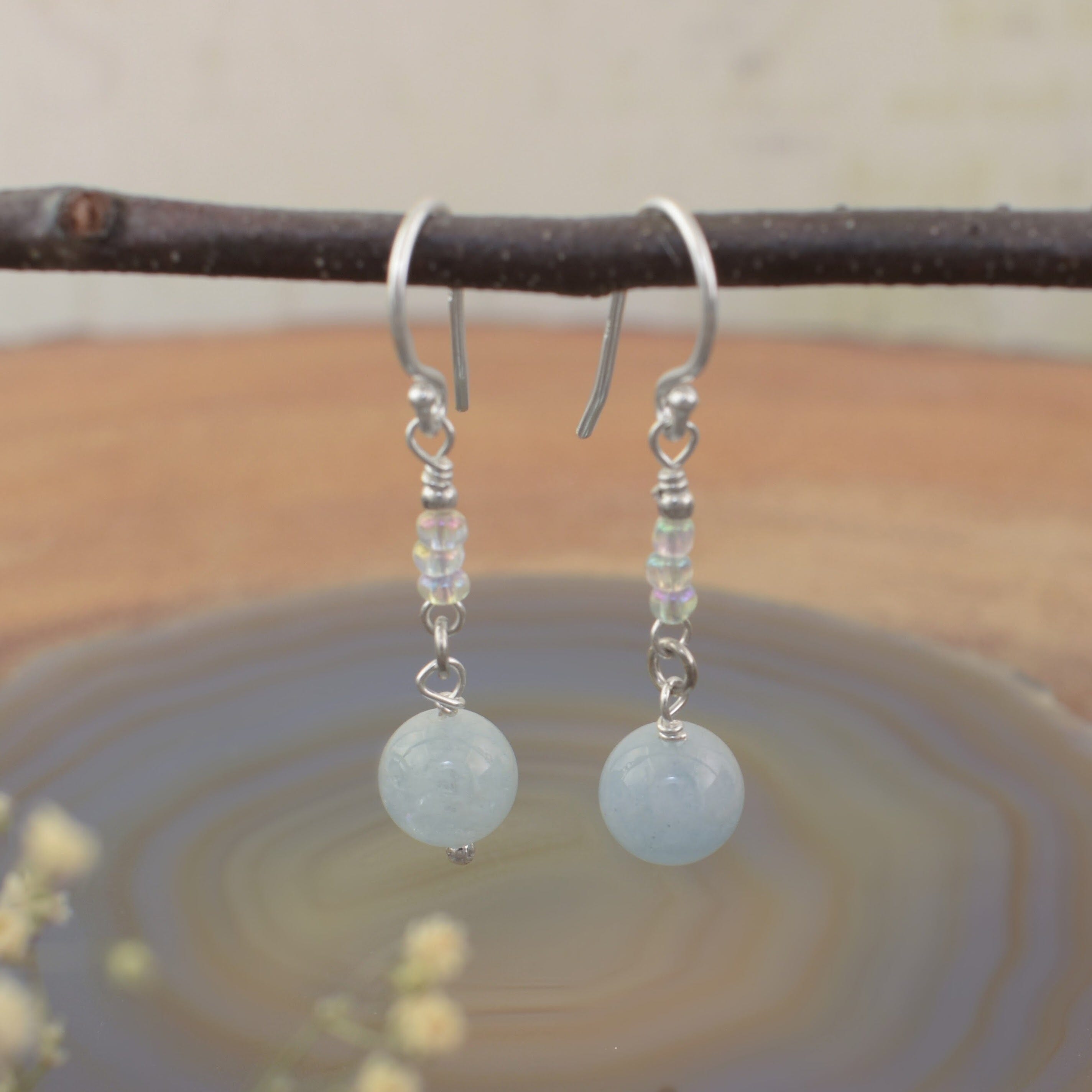 A pair of dangly earrings, with sterling silver hooks and small glass boho beads and milky aqua beads.