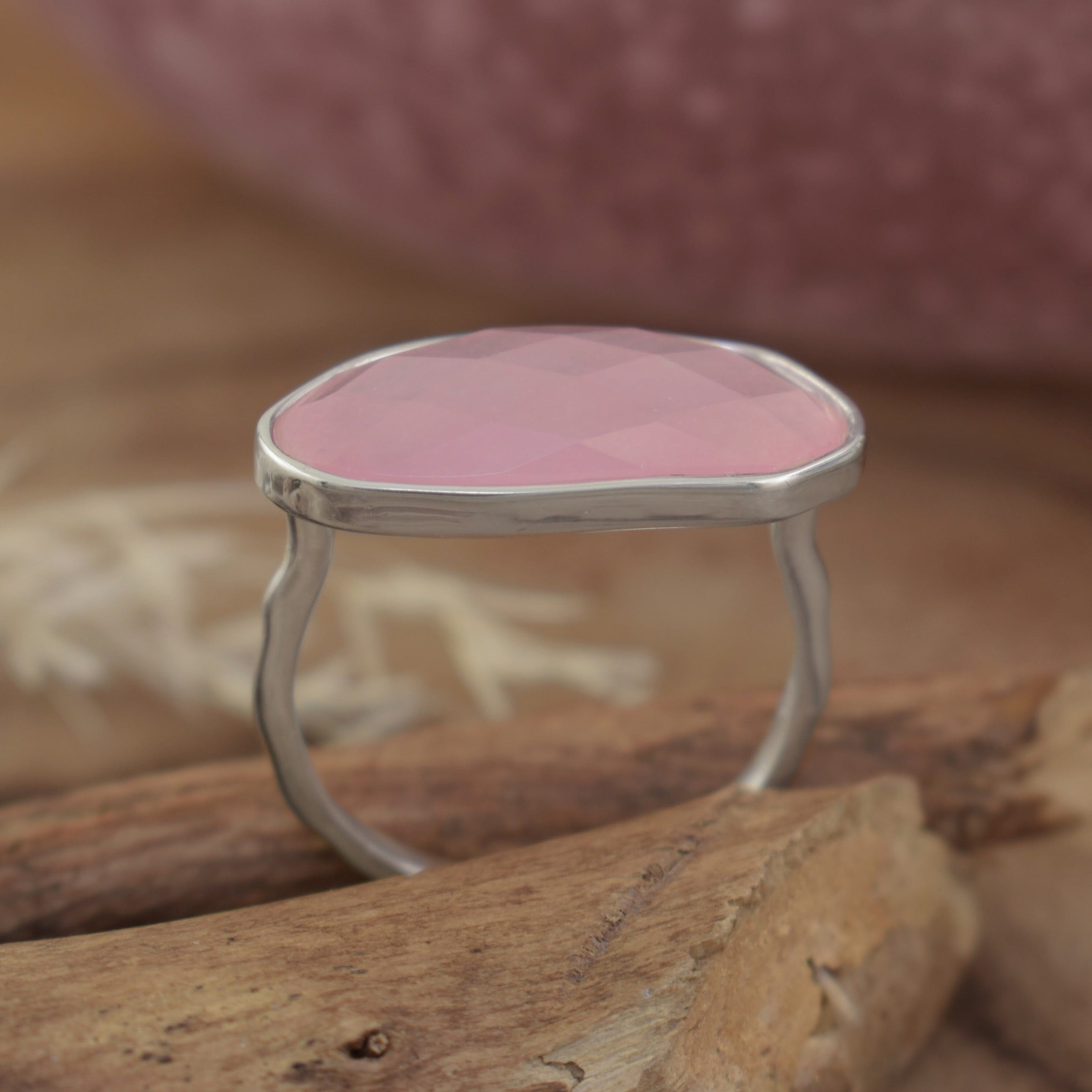 A sterling silver ring with a large oval-shaped pink quartz stone