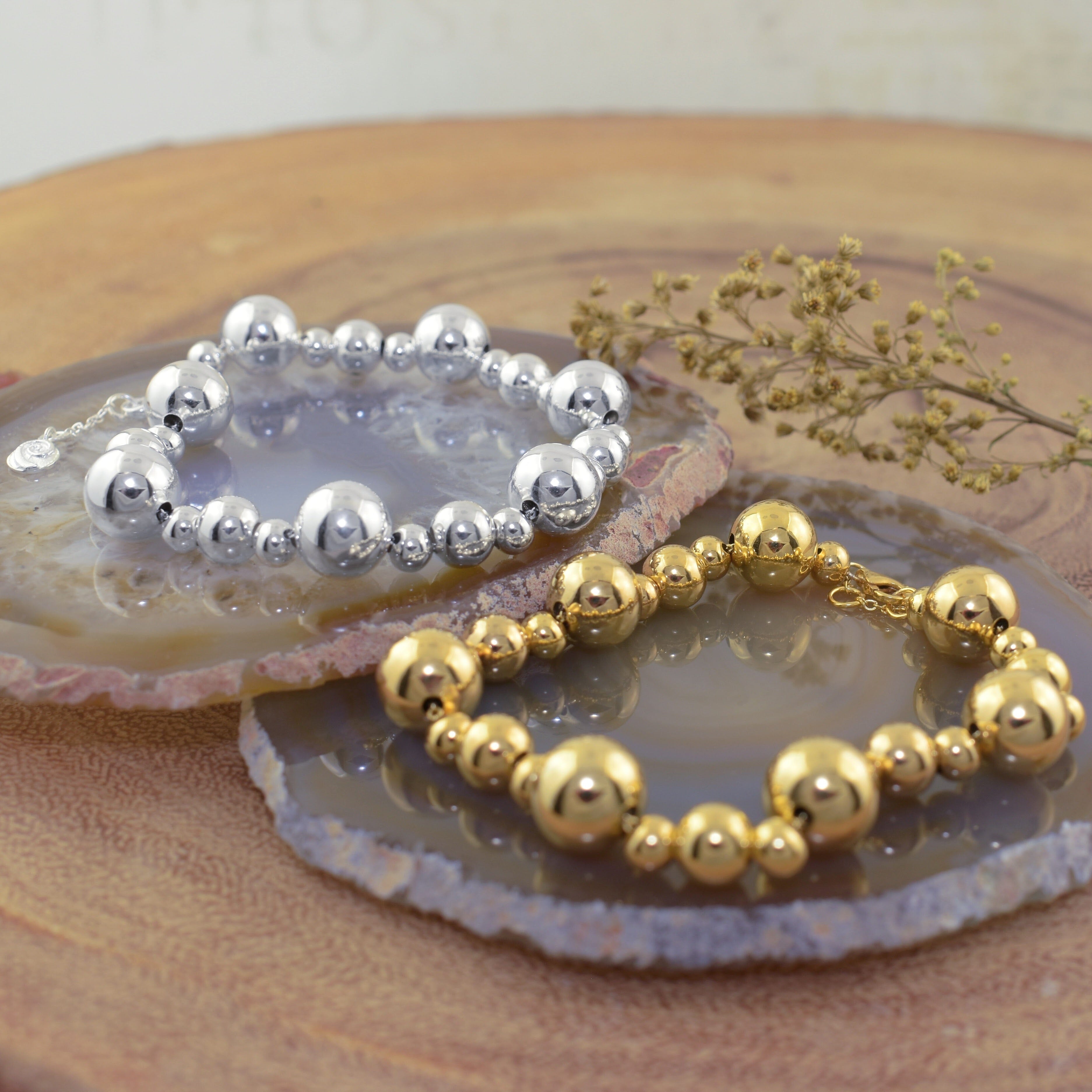 two highly polished beaded bracelets, one silver-plated brass and one gold-plated brass