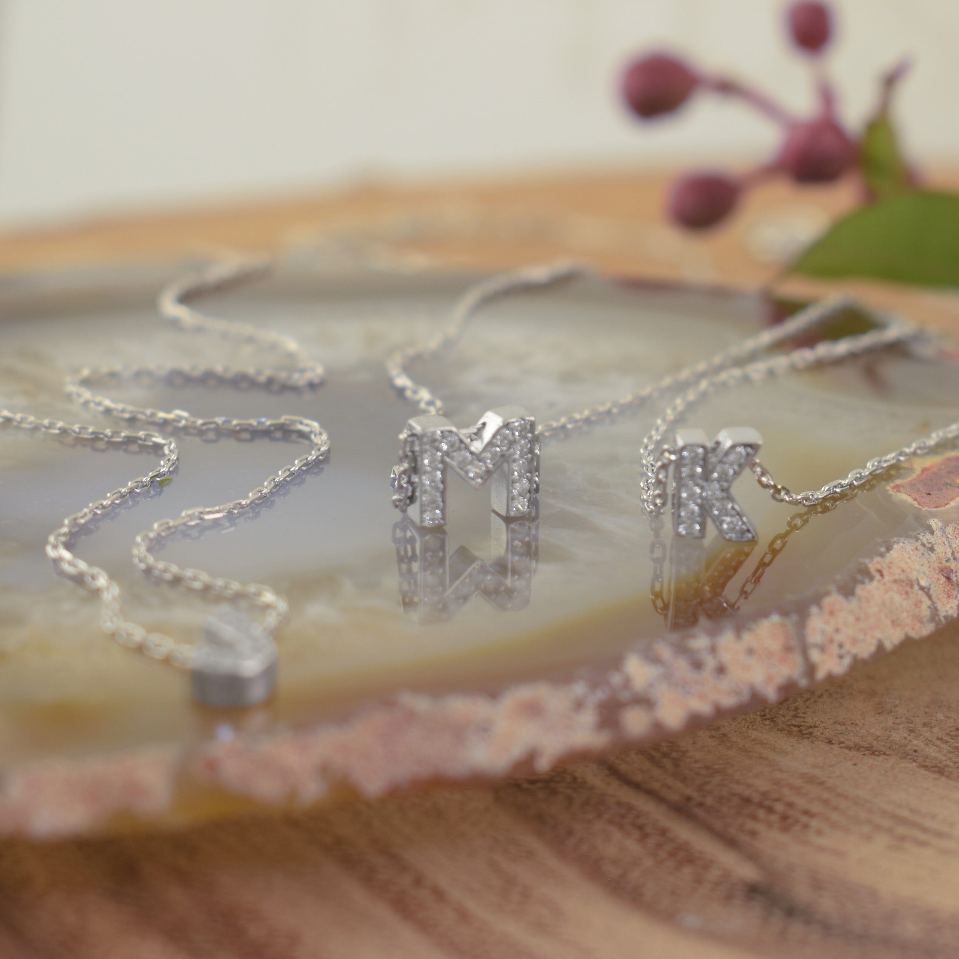 several sterling silver initial necklaces filled with clear CZ stones on one side