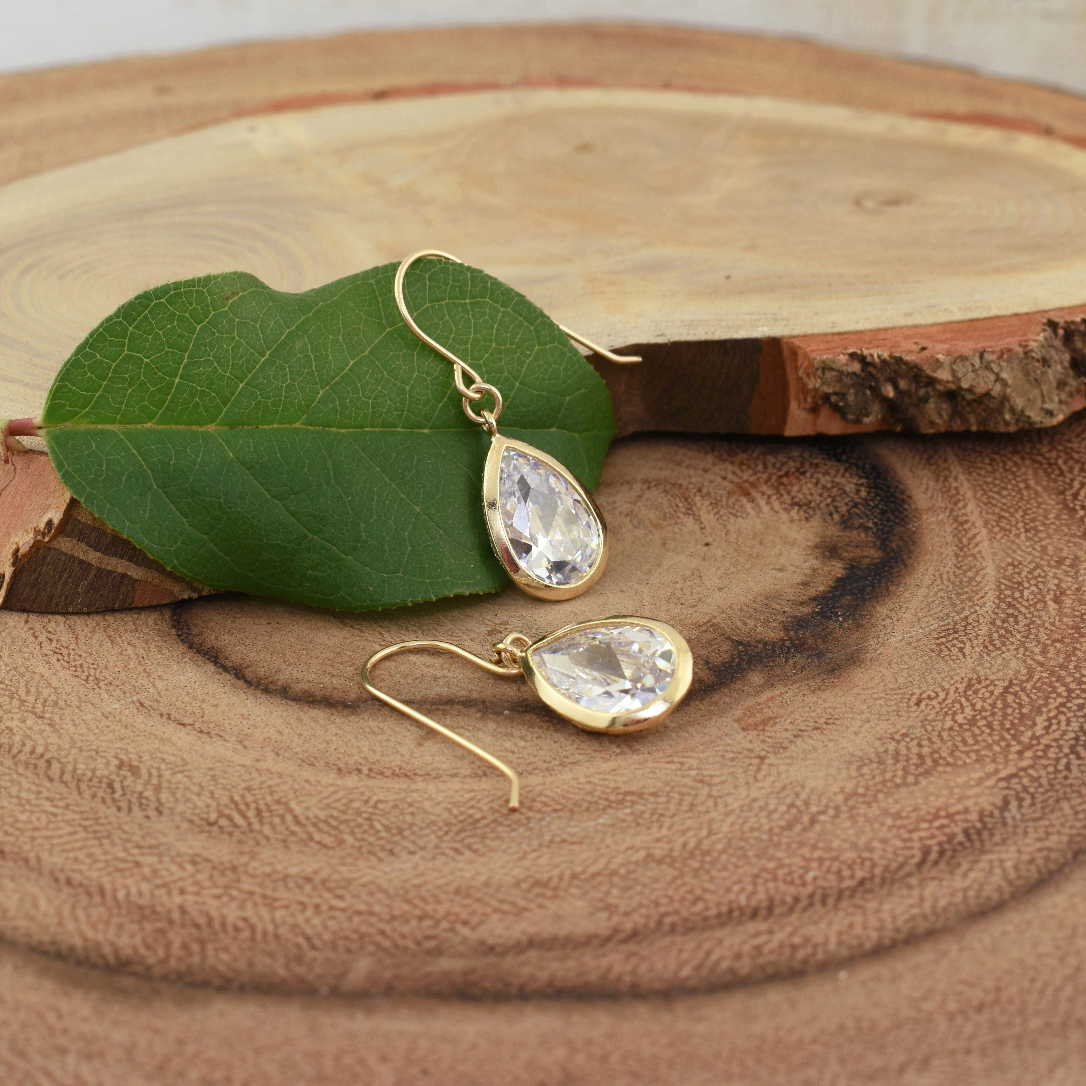 pear shaped dangling earrings with a gold finish