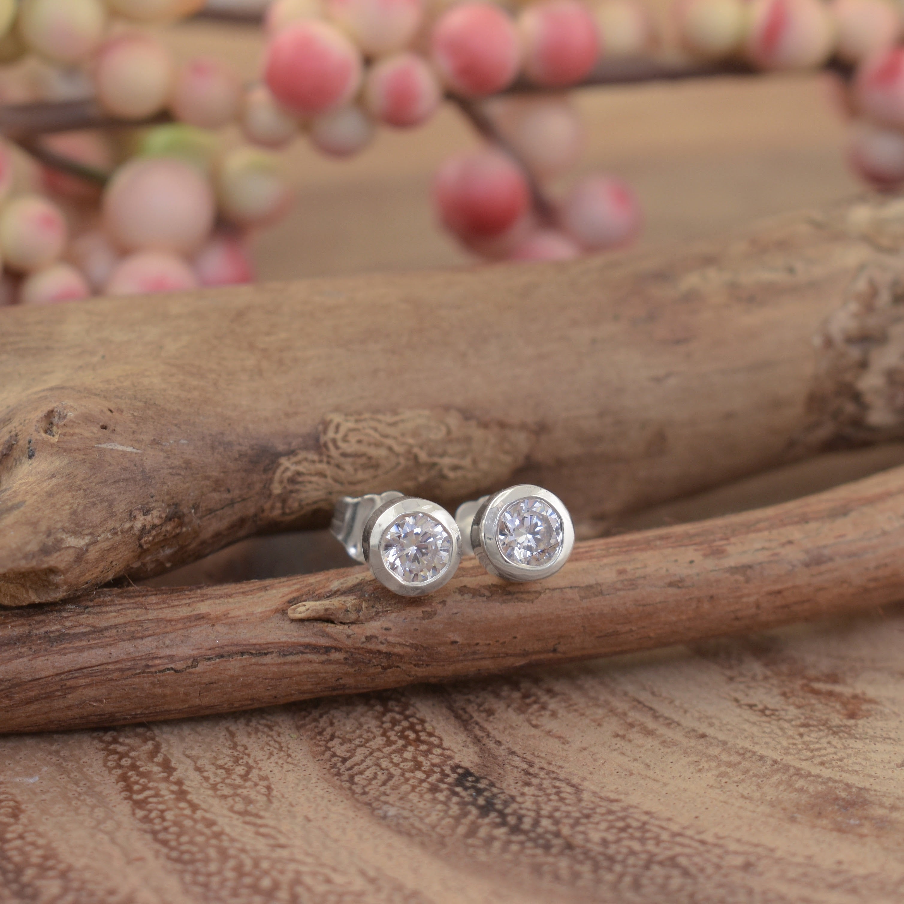 A small pair of sterling silver post earrings with a round clear CZ