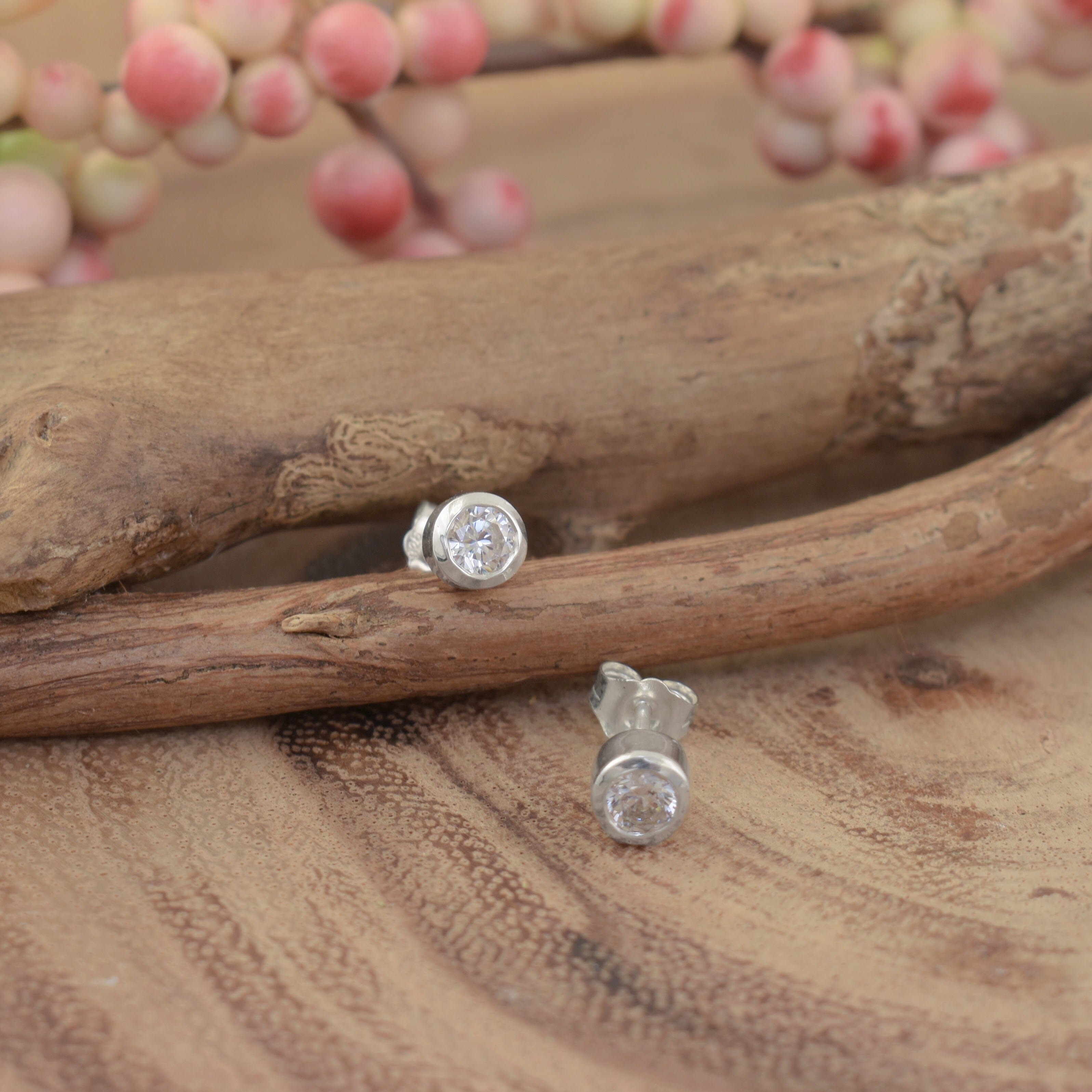 A small pair of post earrings, featuring round clear CZ stones with a high-polish finish