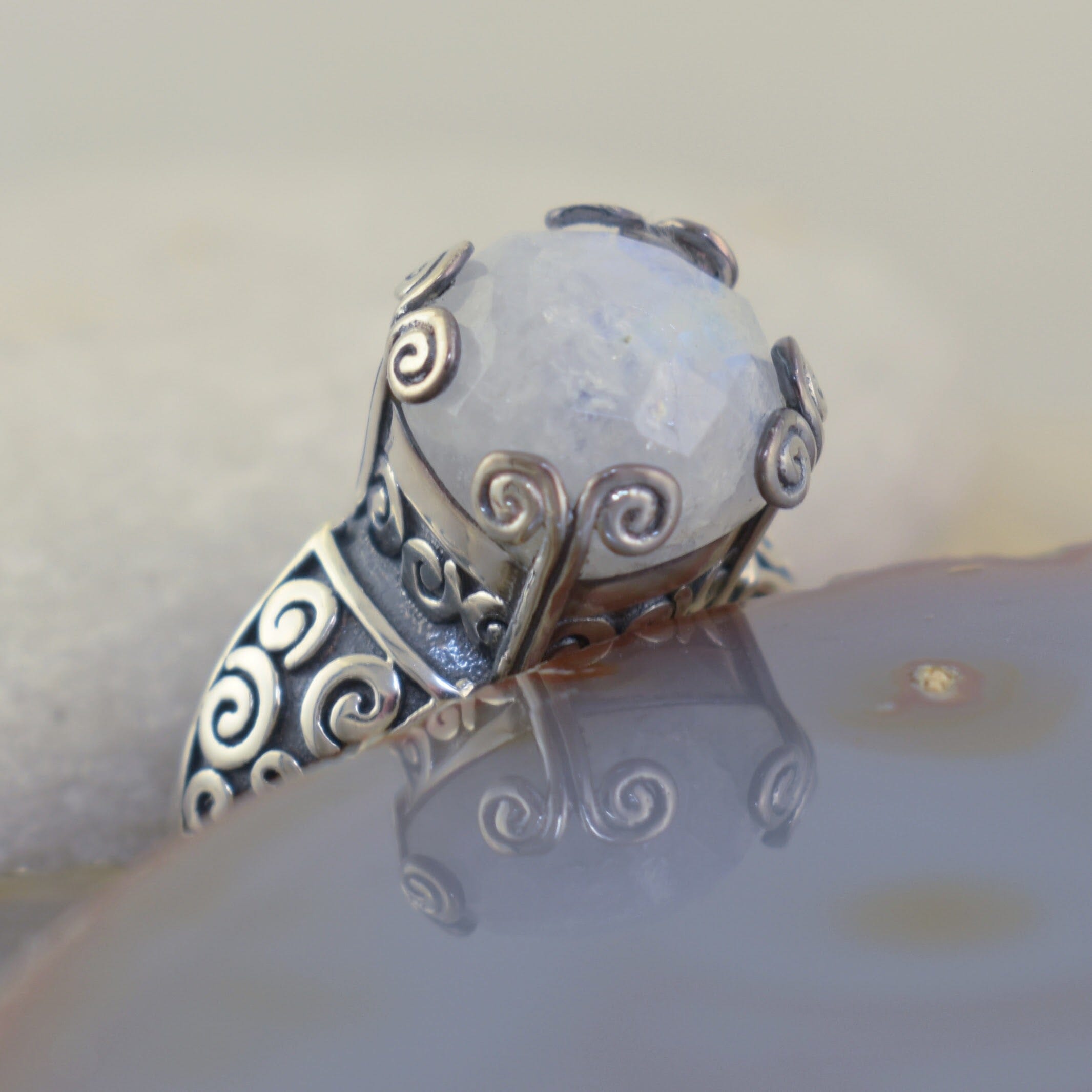 Handcrafted sterling silver swirl ring featuring iridescent rainbow moonstone