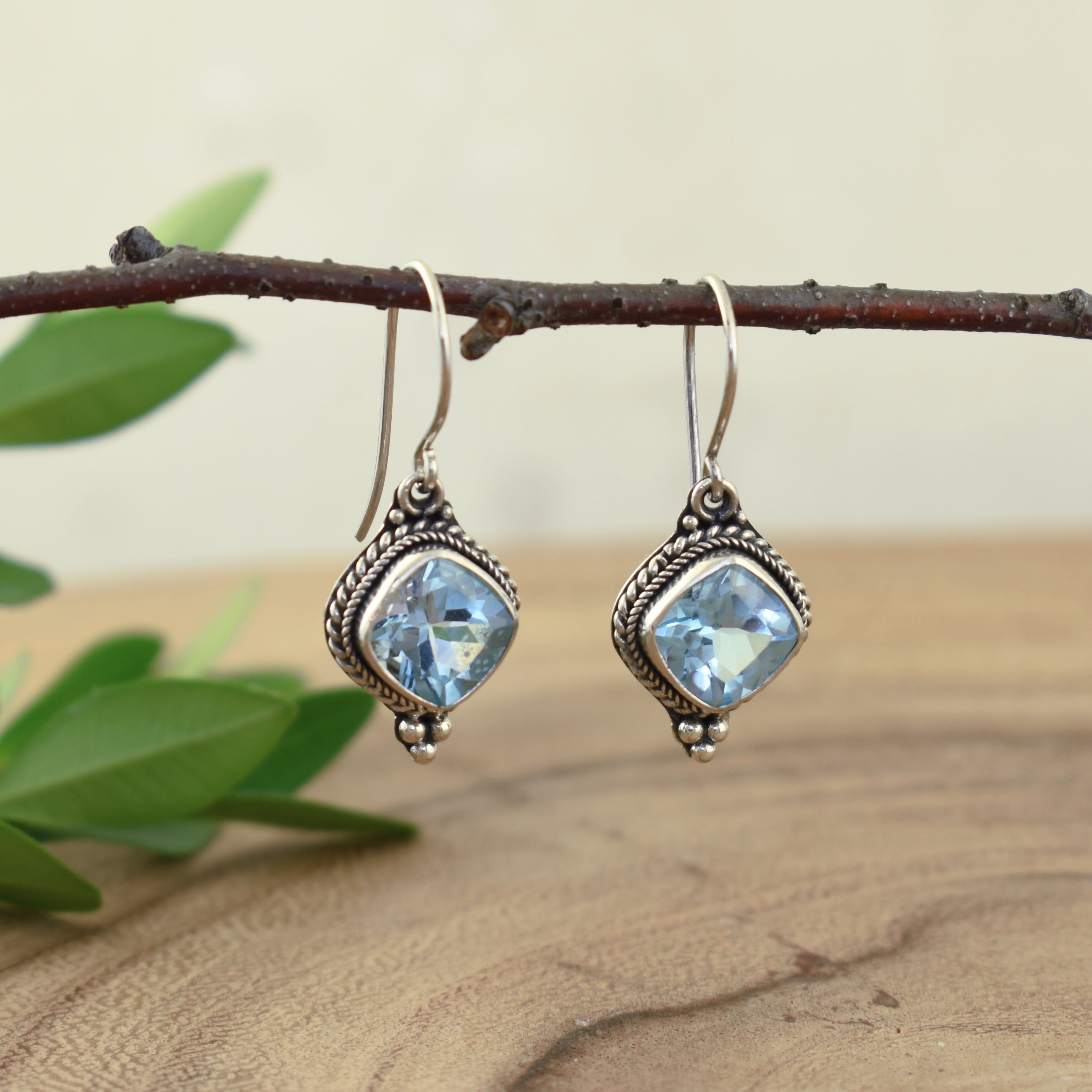 sterling silver french wire earrings featuring cushion cut blue topaz stones