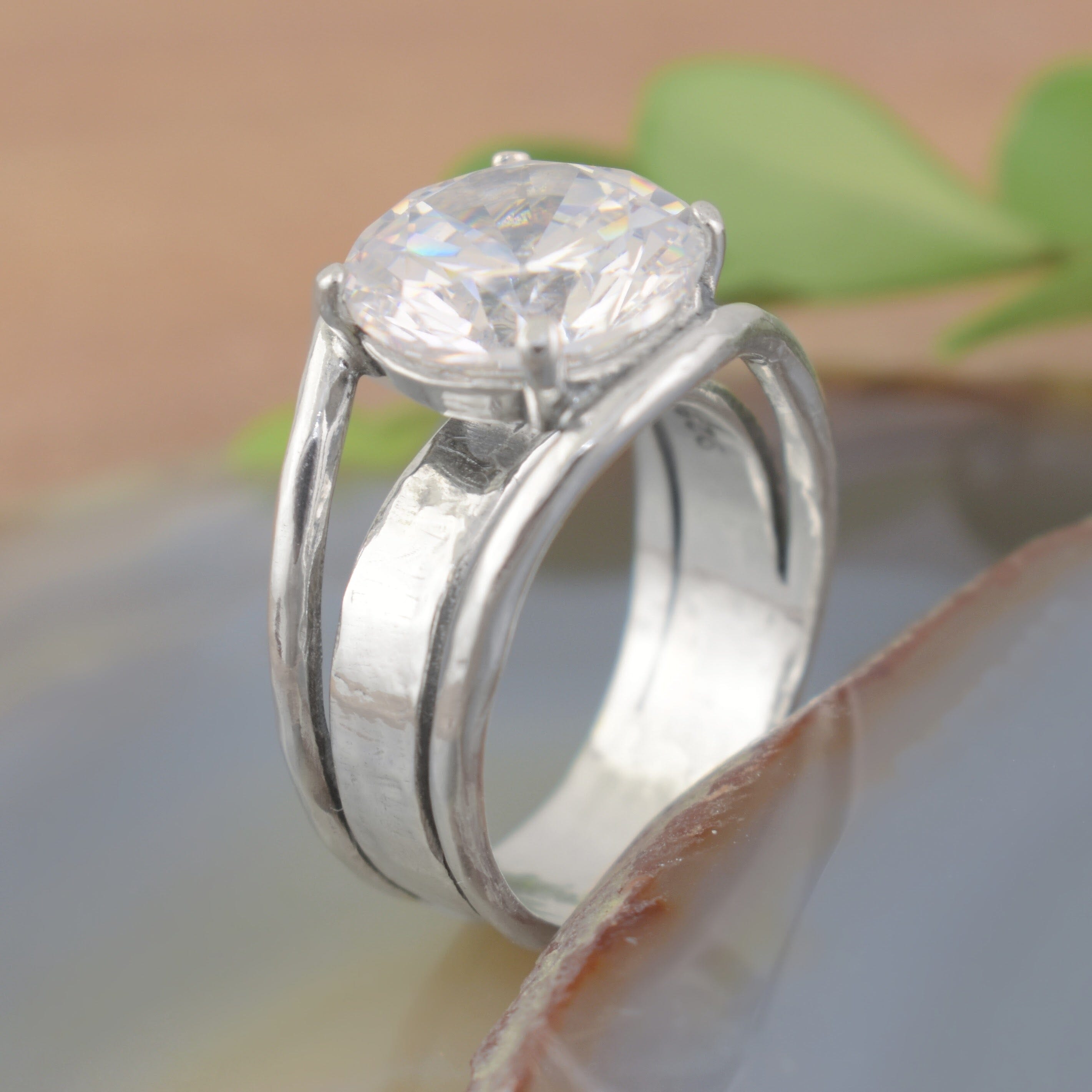 A sterling silver ring featuring a faceted large clear CZ with cut outs in the band
