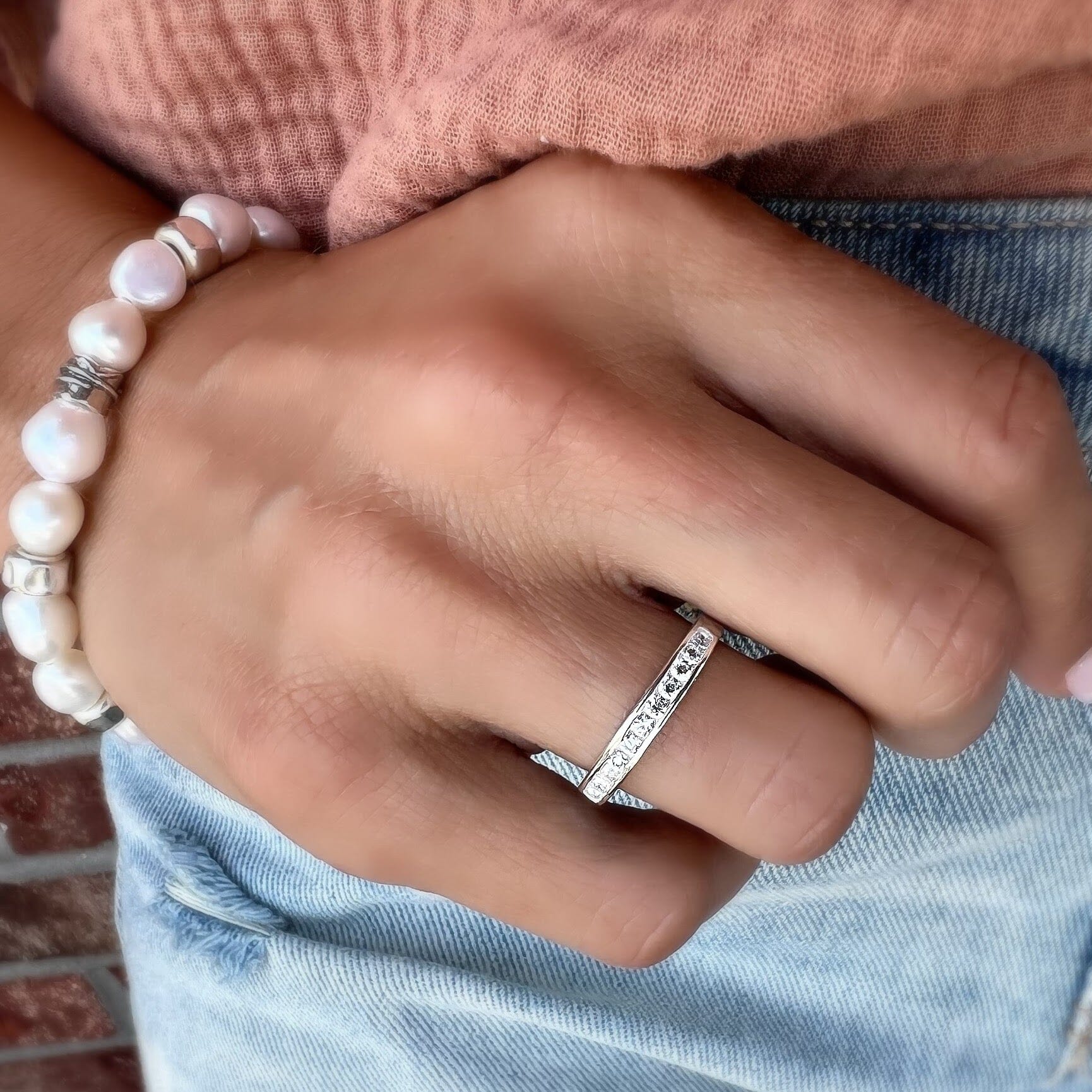 dainty cz ring paired with a pearl bracelet