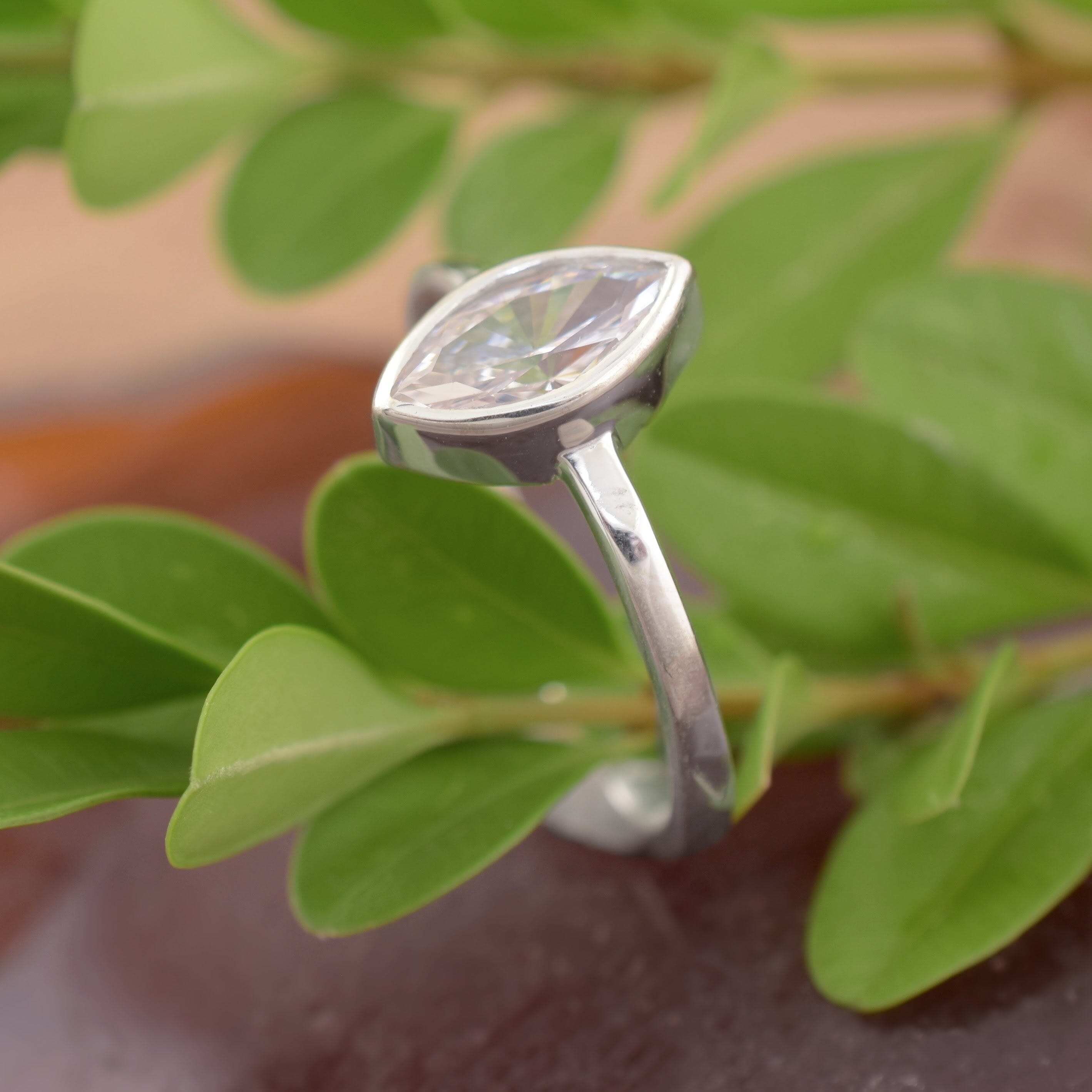 A sterling silver ring with a high-polished band, featuring a marquise-cut clear CZ