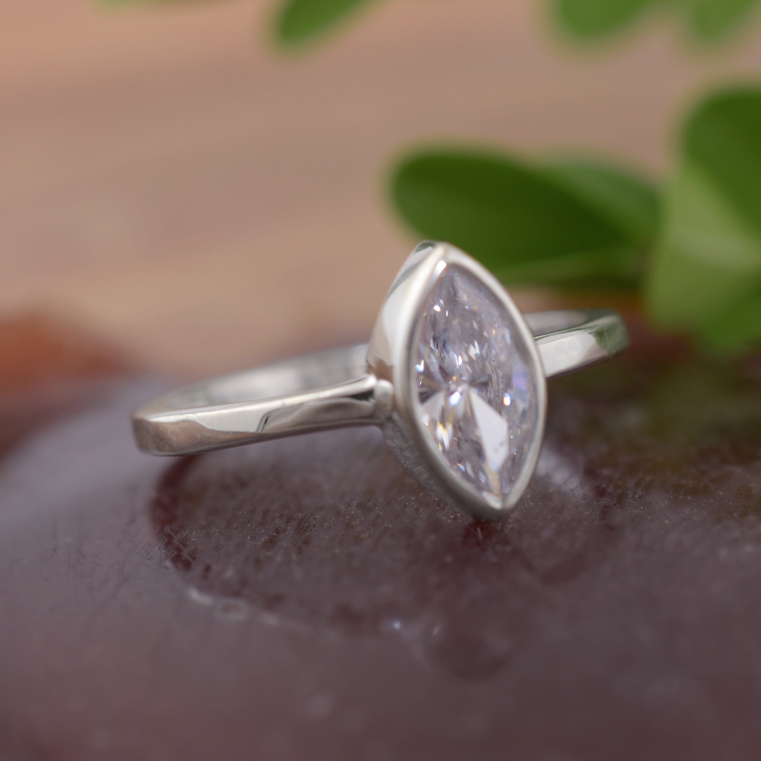 A high-polished sterling silver ring featuring a marquise-cut clear CZ in the center