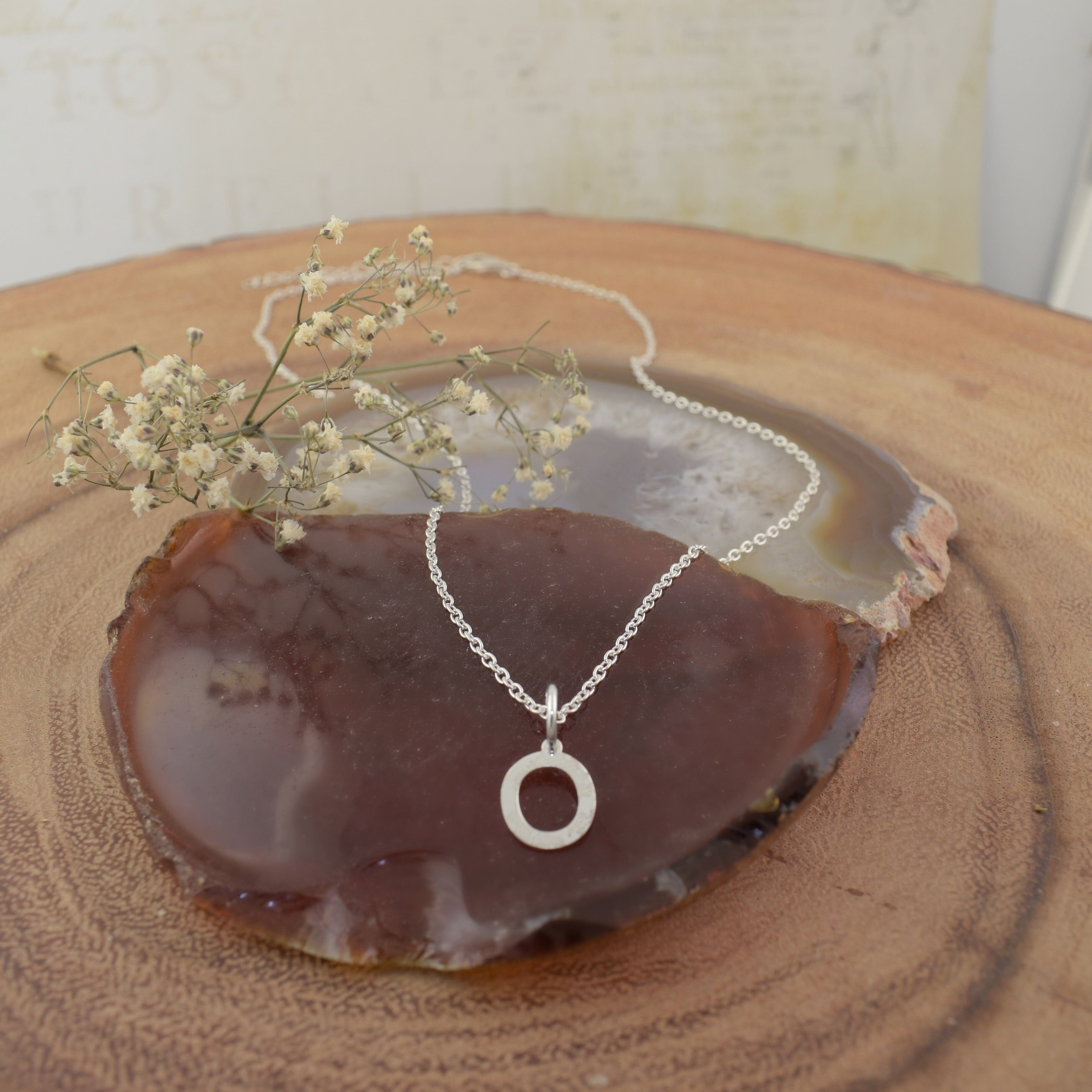 A sterling silver necklace featuring an initial pendant "O"