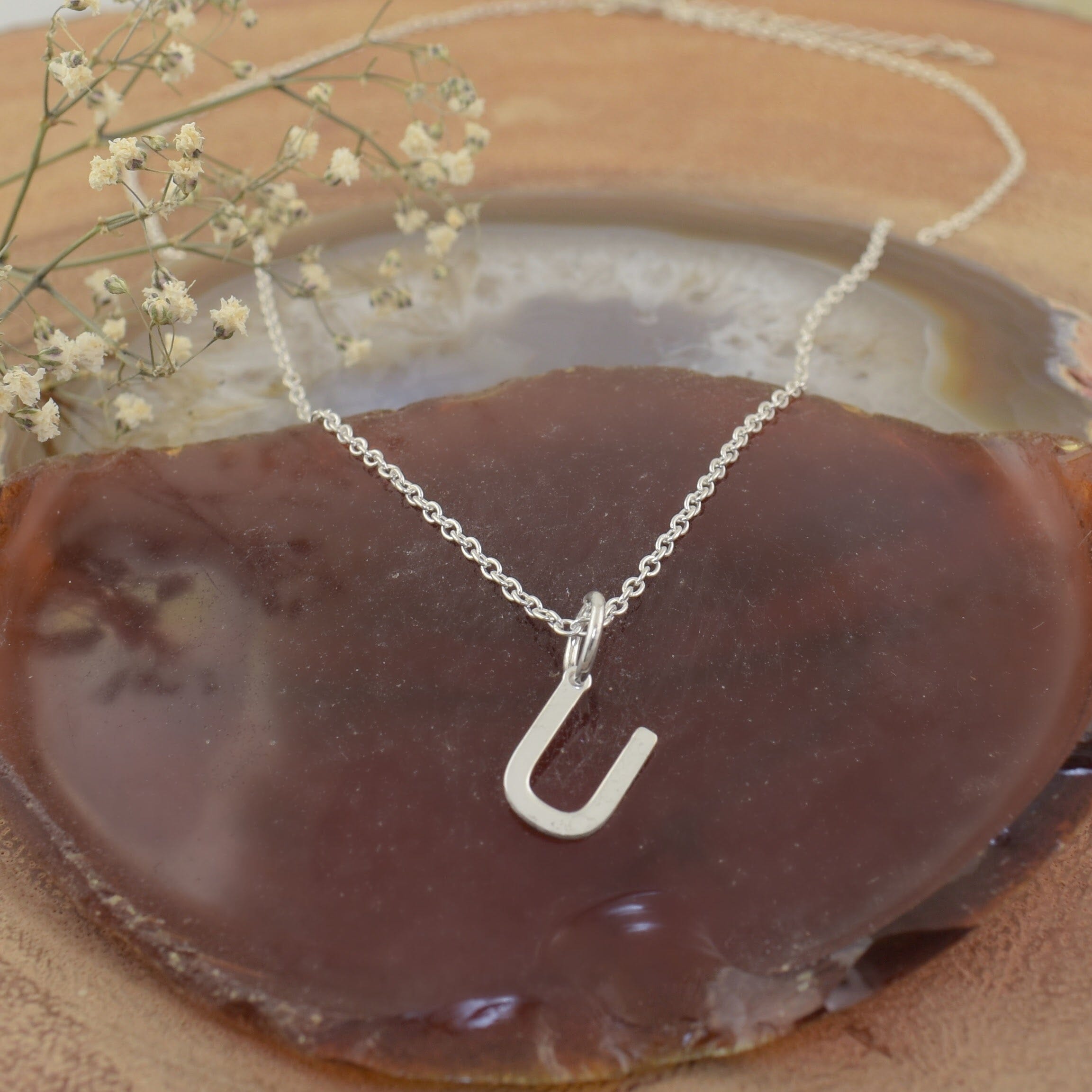 A sterling silver necklace featuring a high polished U pendant