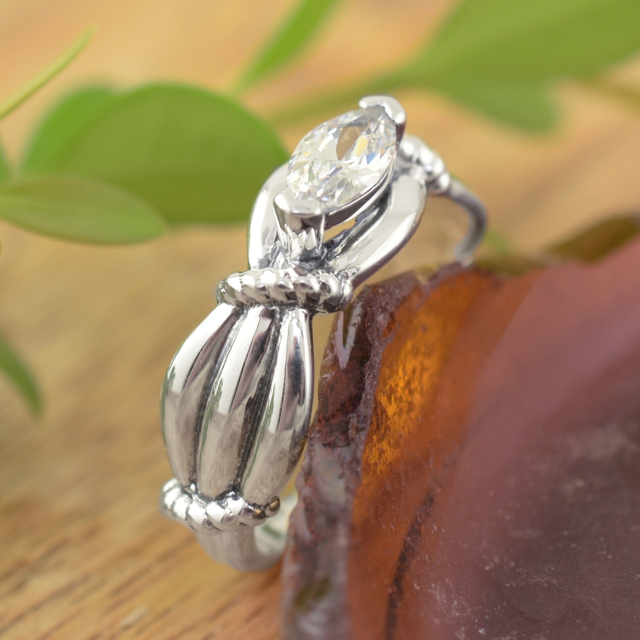 a sterling silver ring with a marquise-cut clear gemstone and sculpted organic shapes