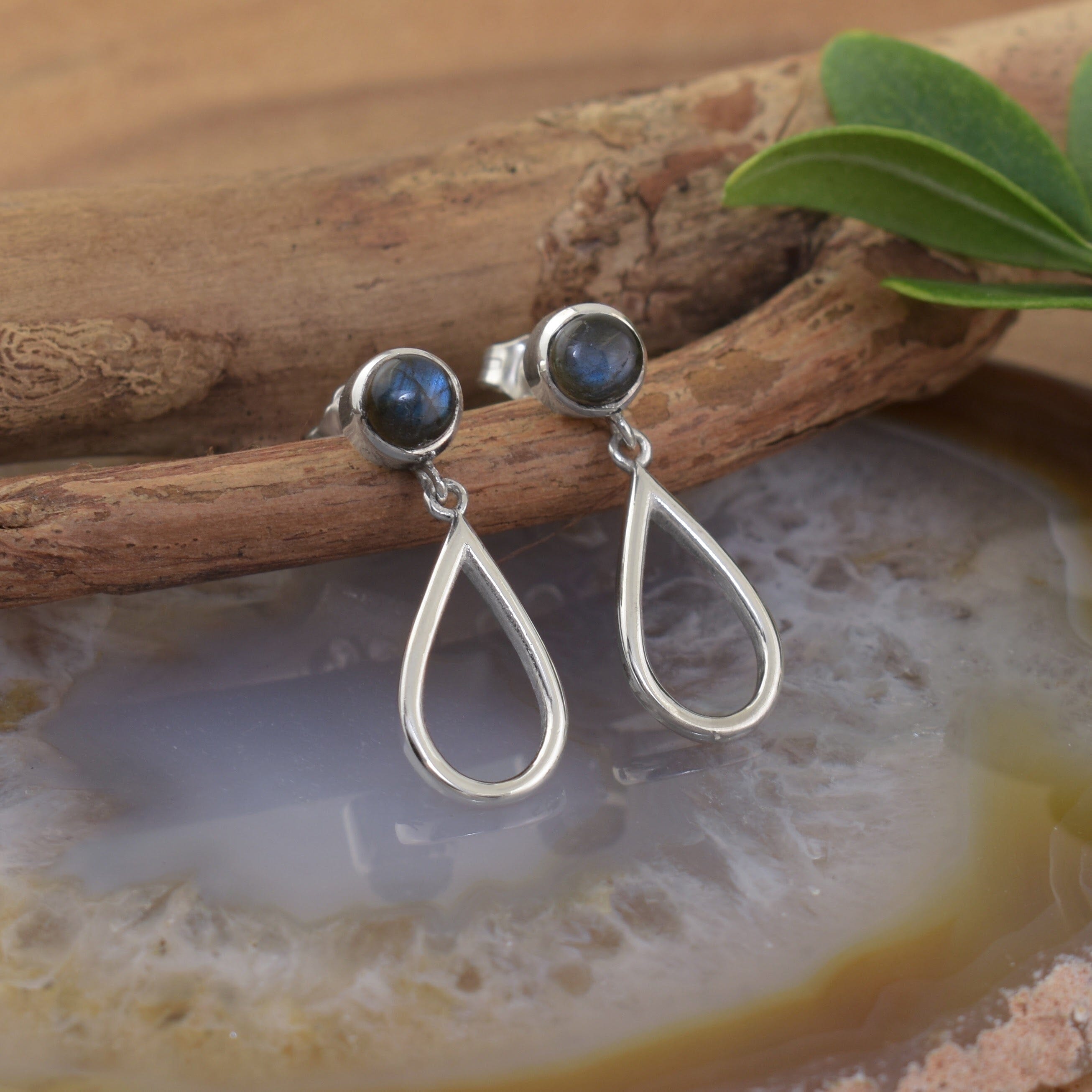 A pair of sterling silver post earrings with labradorite stones and teardrop shaped silver dangling beneath