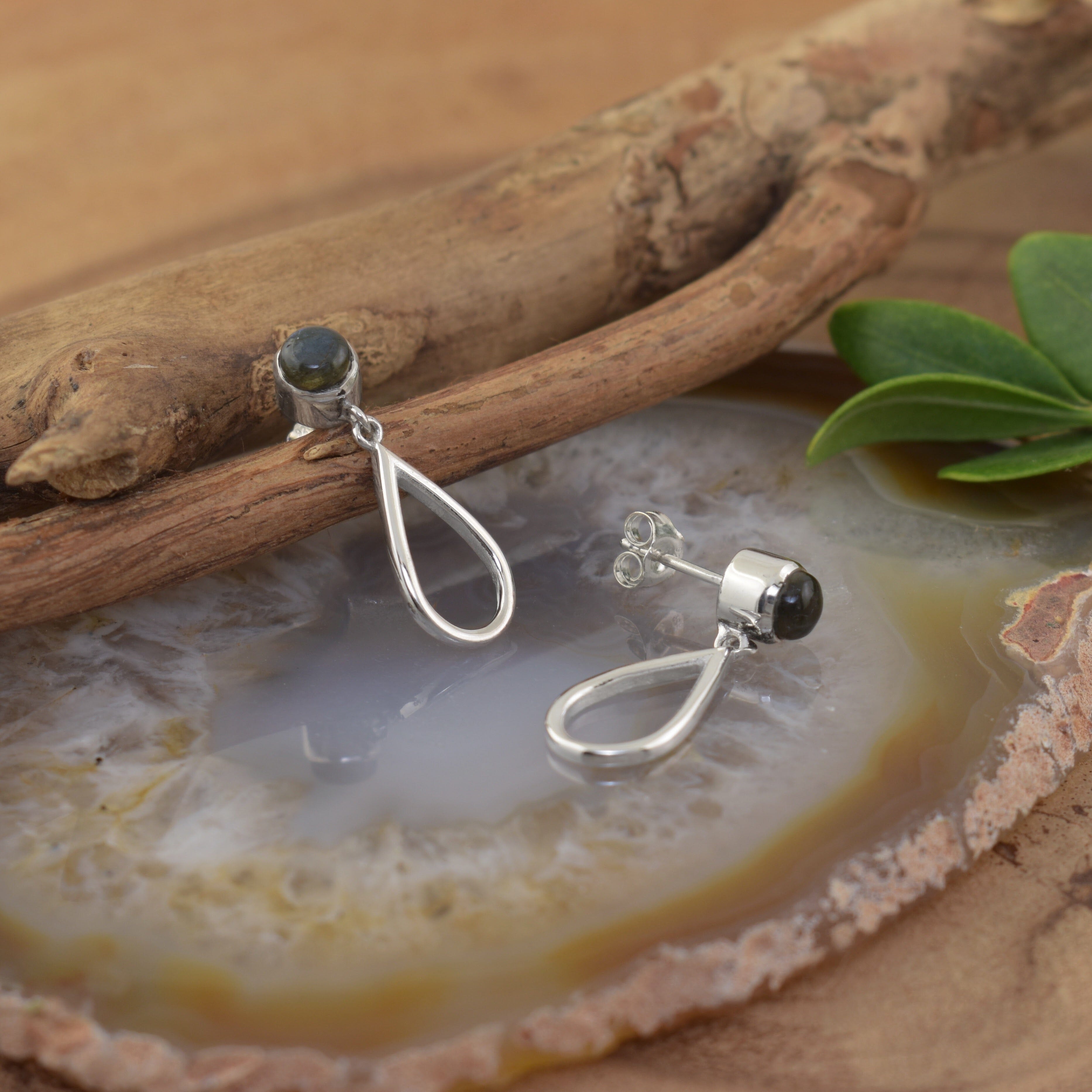 A pair of sterling silver post earrings with a labradorite stone, featuring silver cutout teardrops dangling beneath