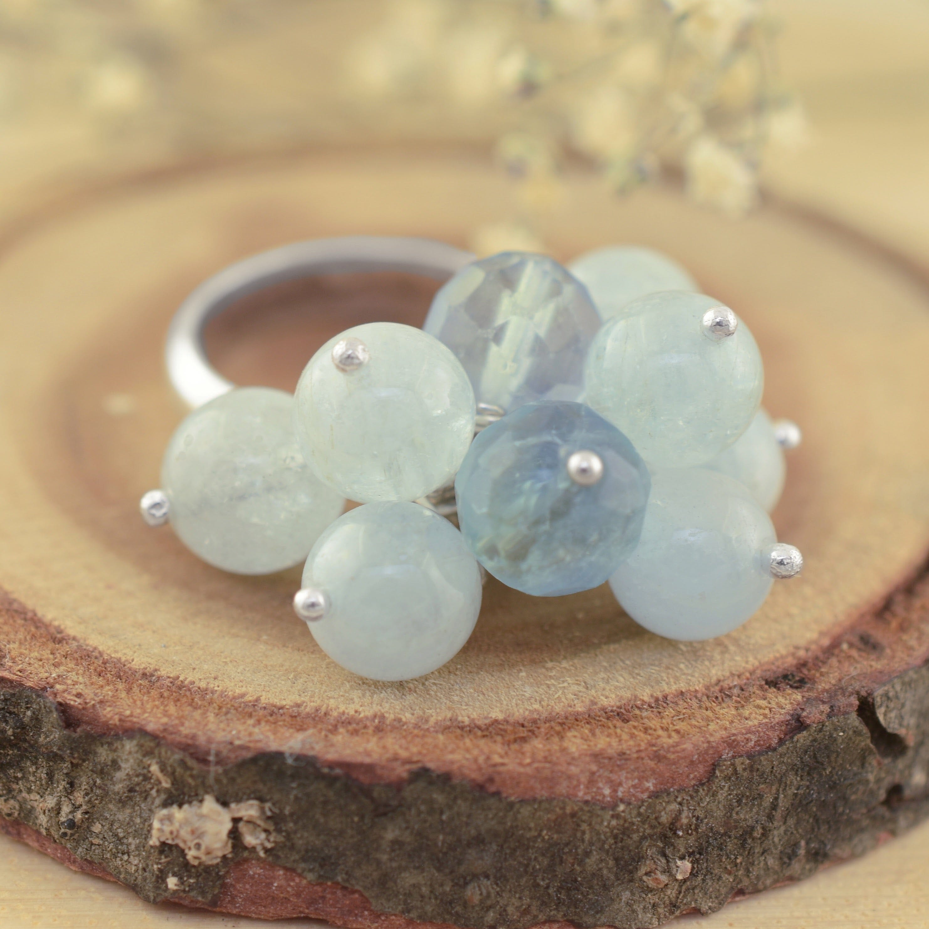 A sterling silver ring with pale aqua beads attached in a cluster