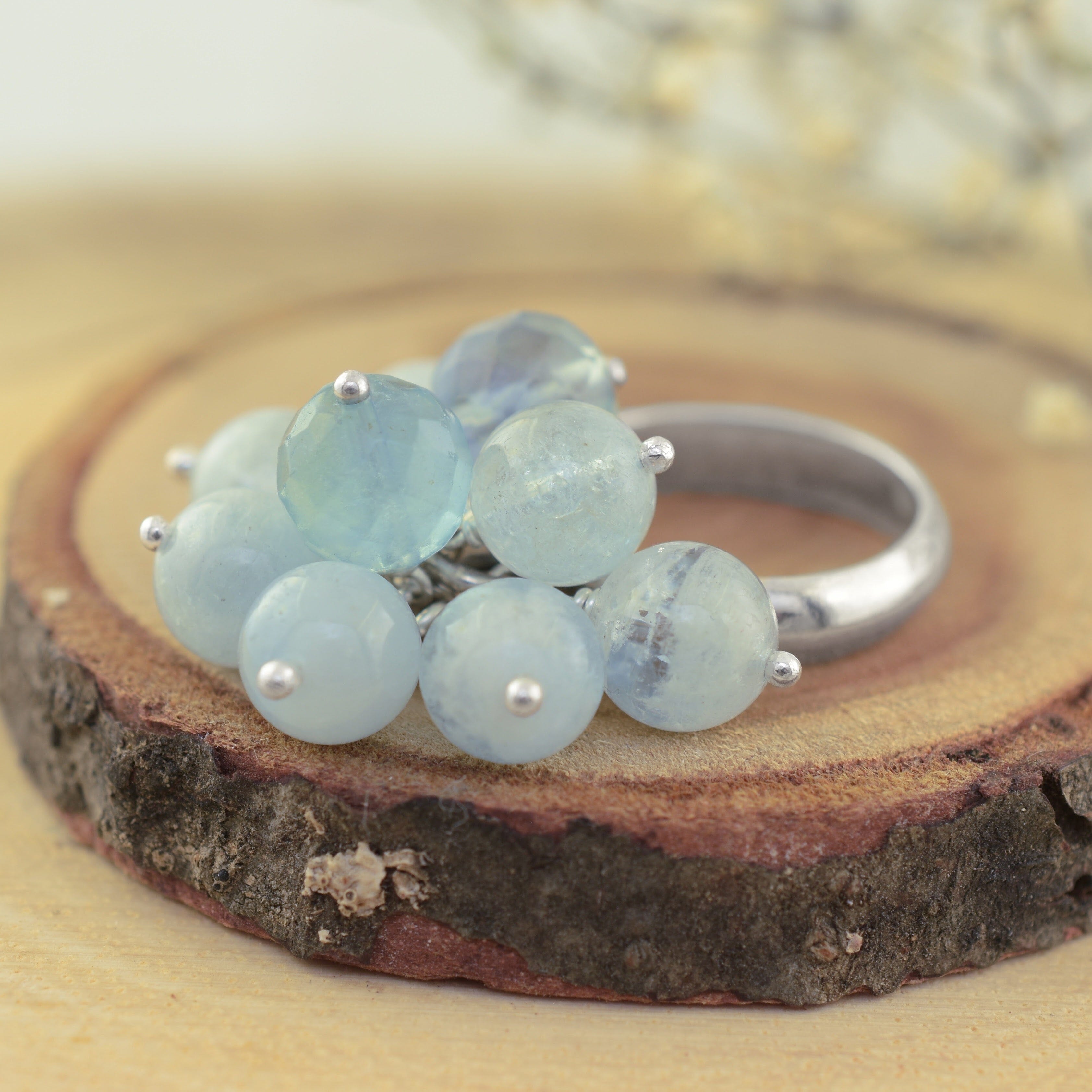 A sterling silver ring with pale aqua beads attached in a cluster