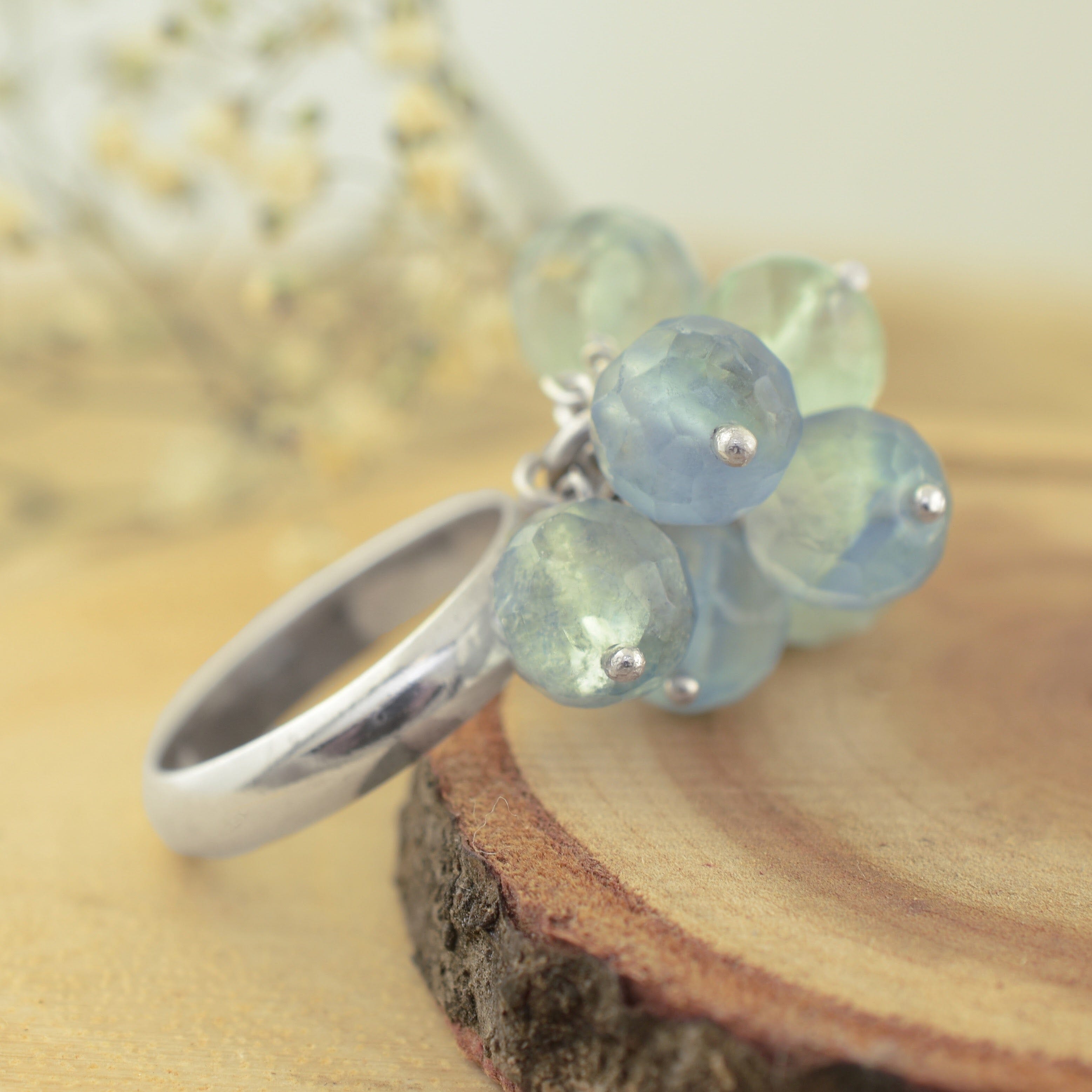 A sterling silver ring featuring a cluster of faceted light blue beads