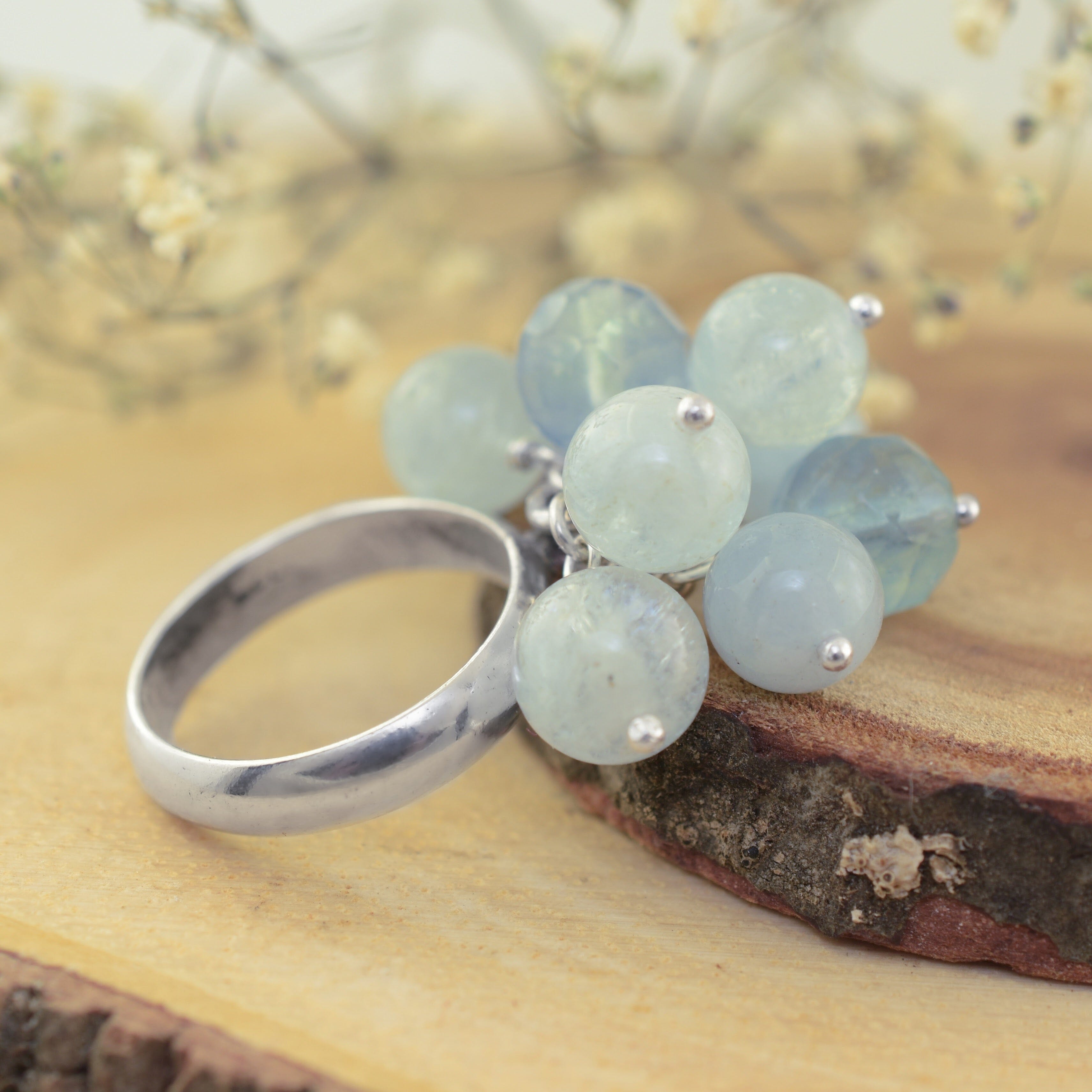 A sterling silver ring with pale aqua beads attached in a cluster