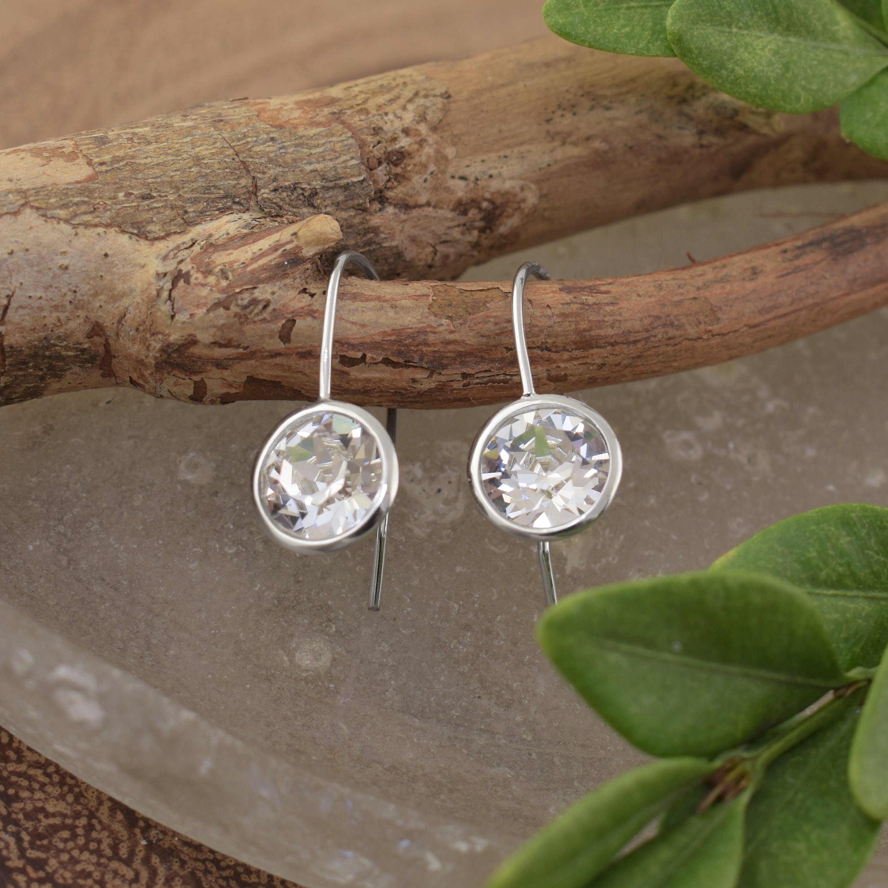 A pair of sterling silver hook earrings with a large austrian crystal stone