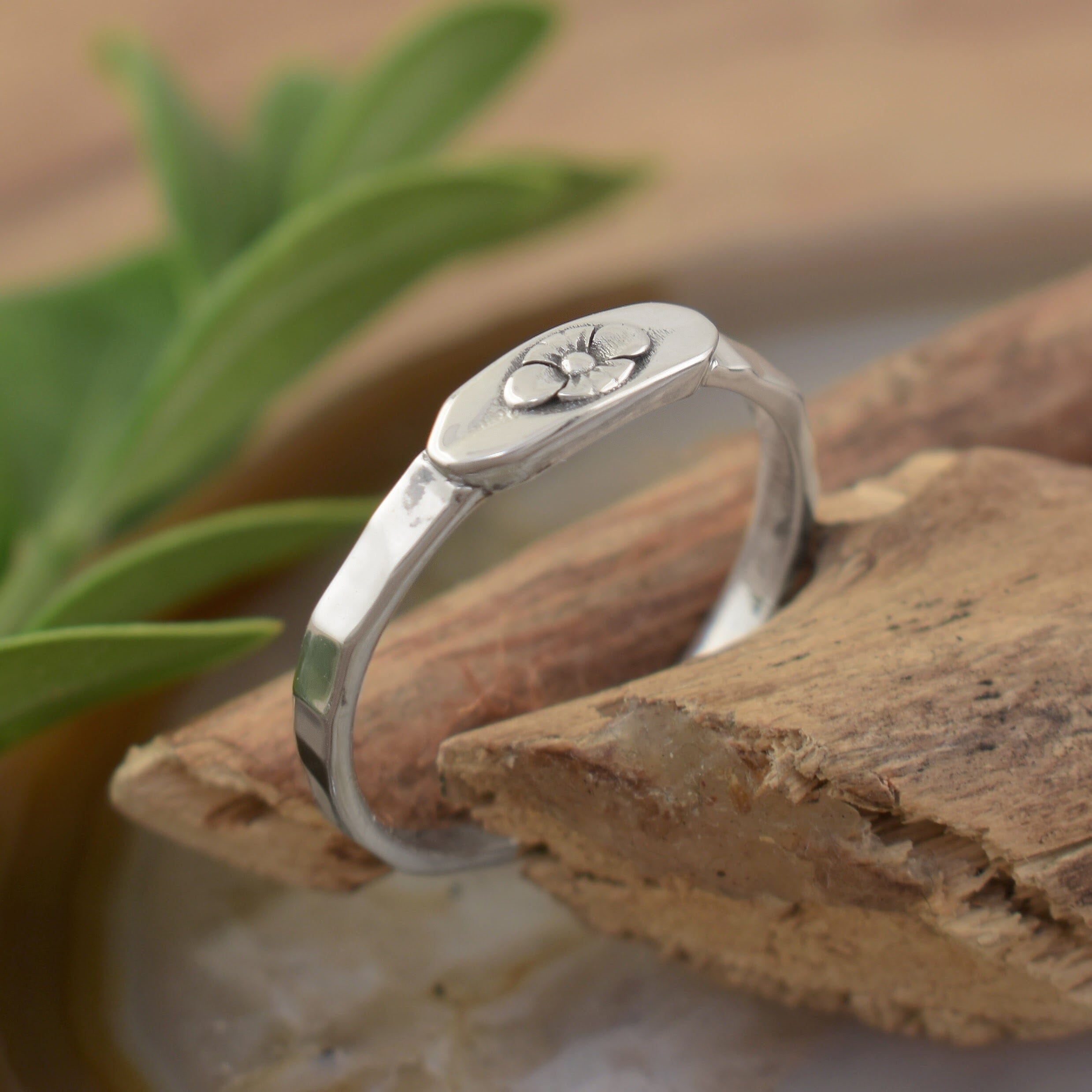 A small sterling silver ring featuring a flower detail in the center