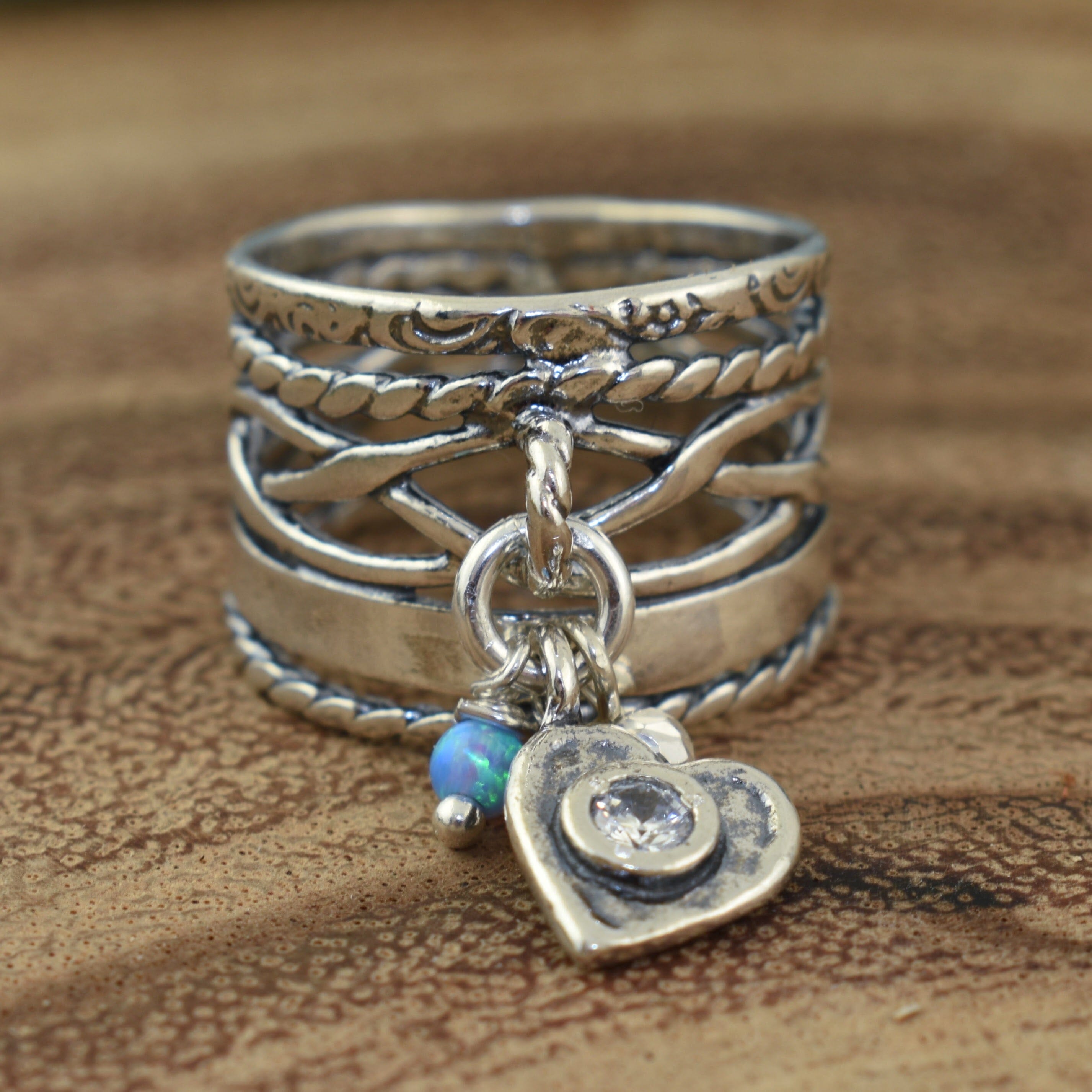 silver ring featuring a heart, opal, and silver bead elements
