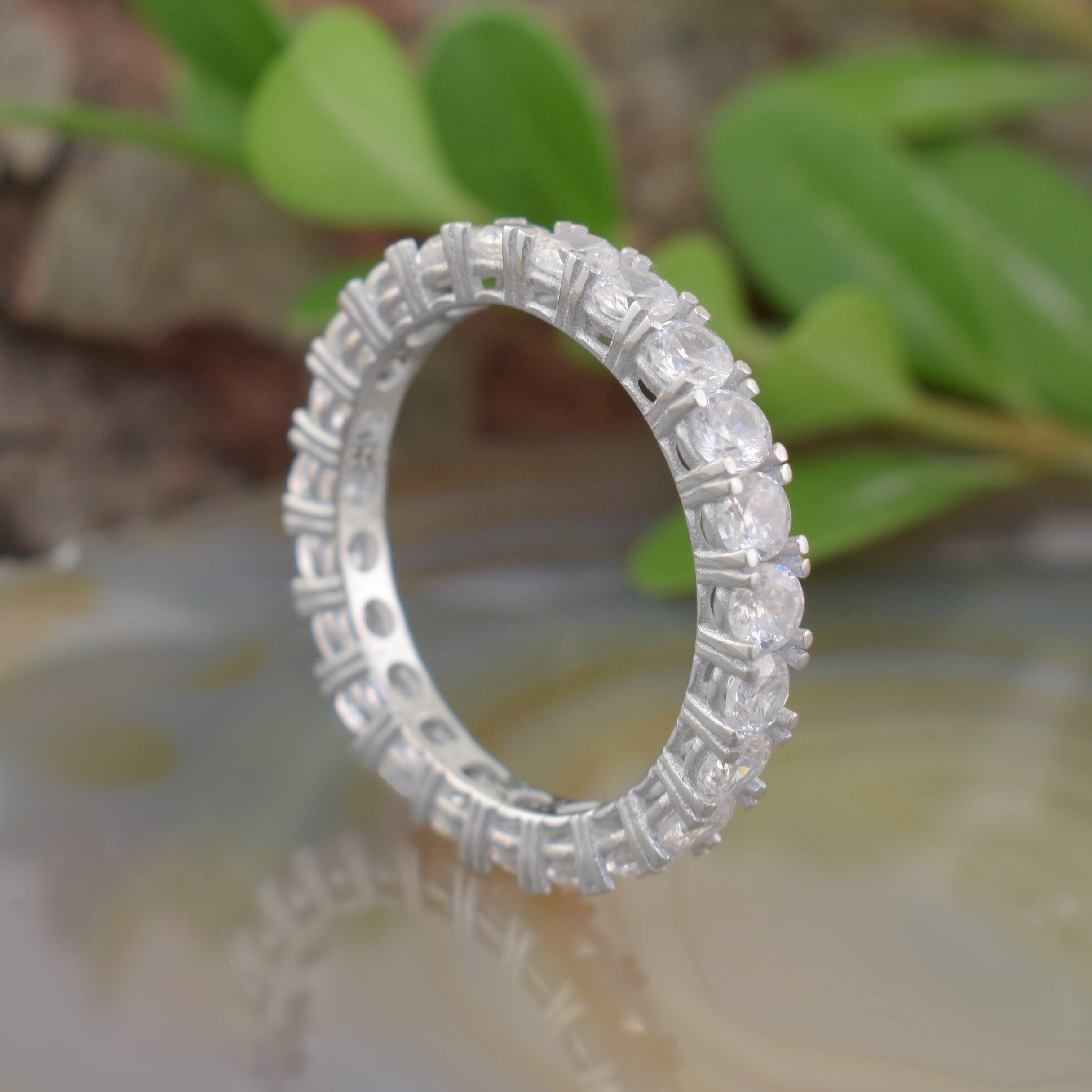 A silver eternity ring with small Zircon stones surrounding the outside of the band