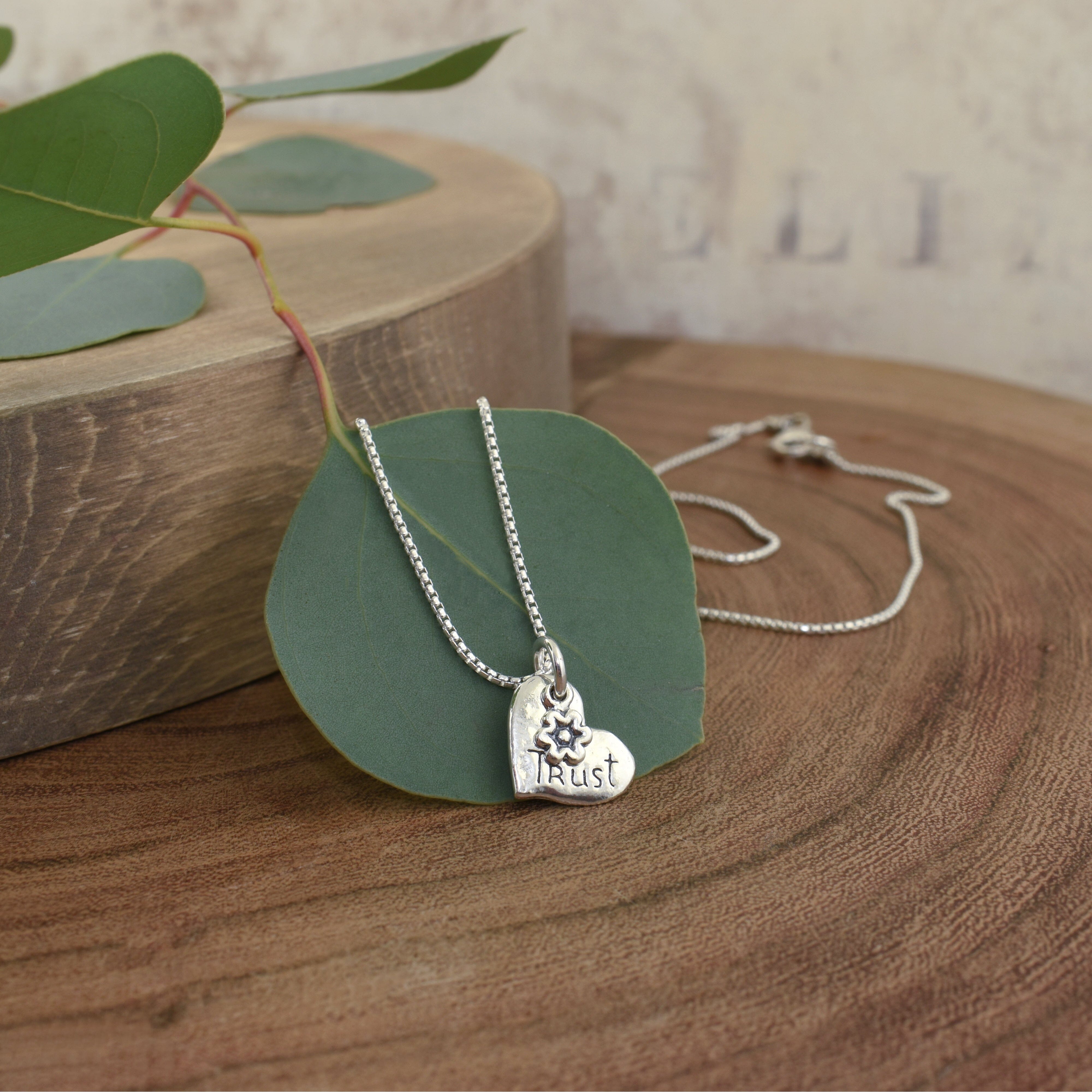 dainty sterling silver heart necklace hand-stamped with the word trust