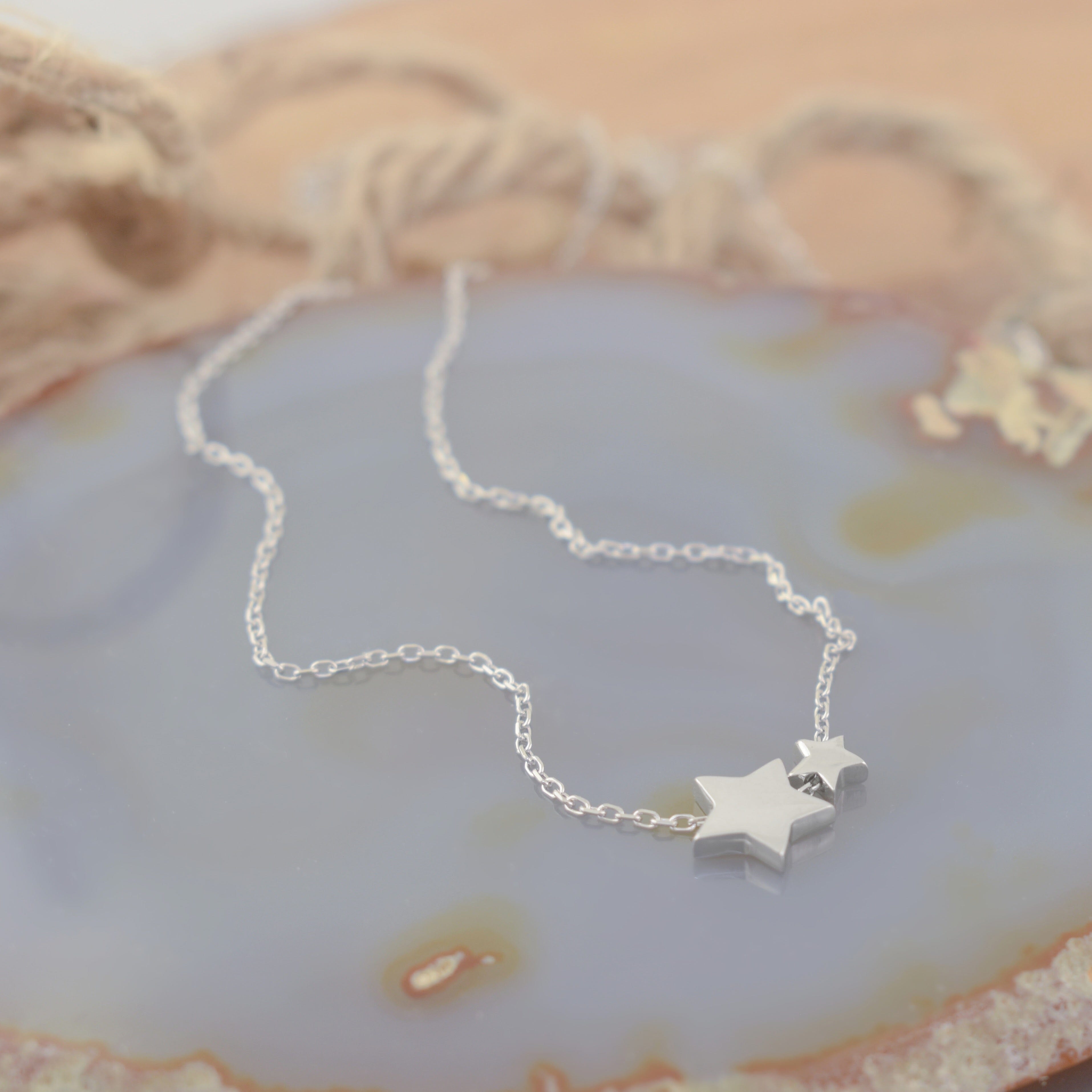A sterling silver necklace featuring two small star pendants