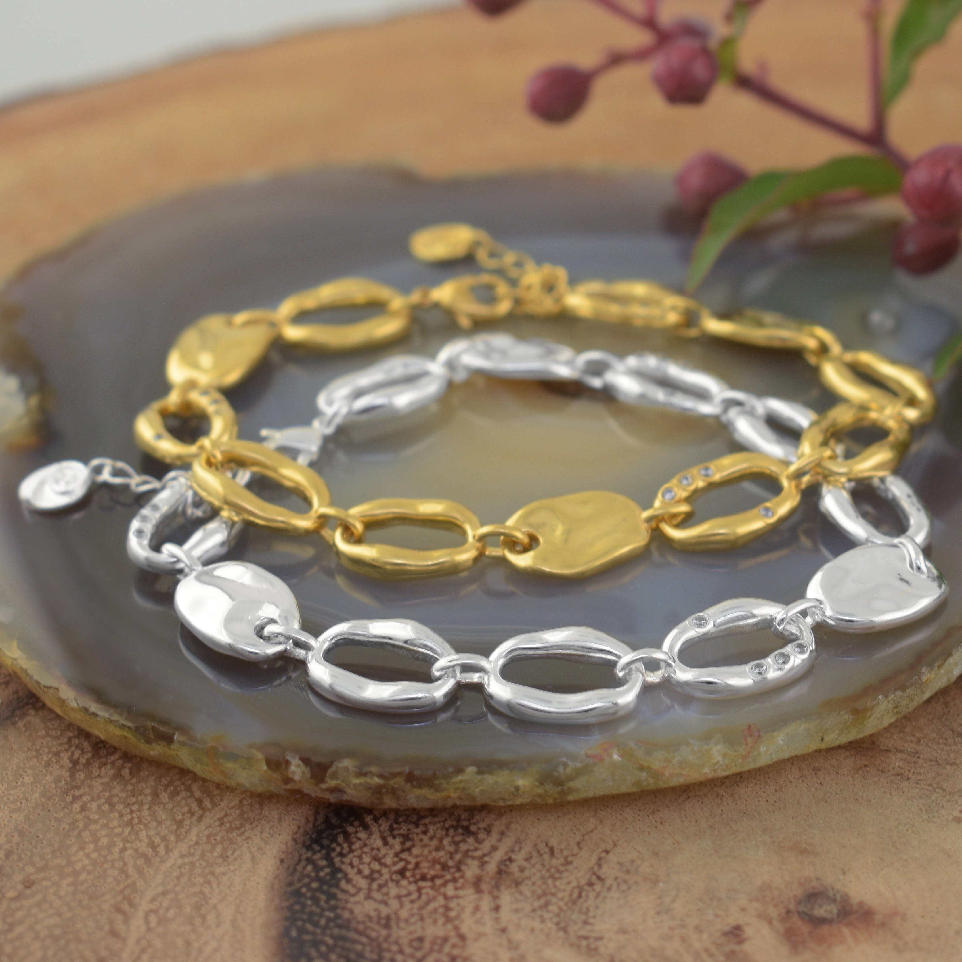 two chain link bracelets, one in polished gold and one in polished silver with tiny CZ stones scattered on the chain links