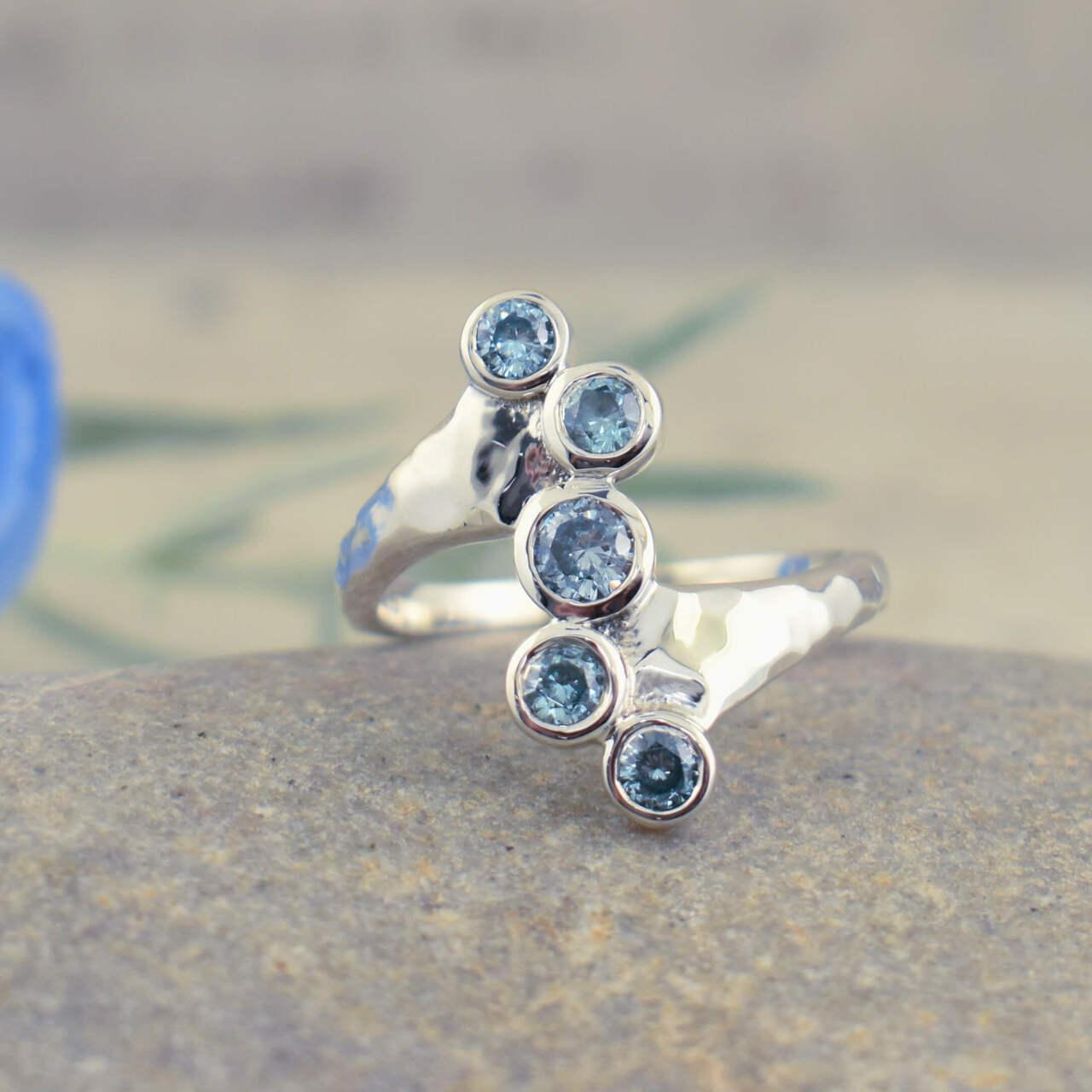 Handcrafted sterling silver hammered band ring with sky blue cubic zirconia stones