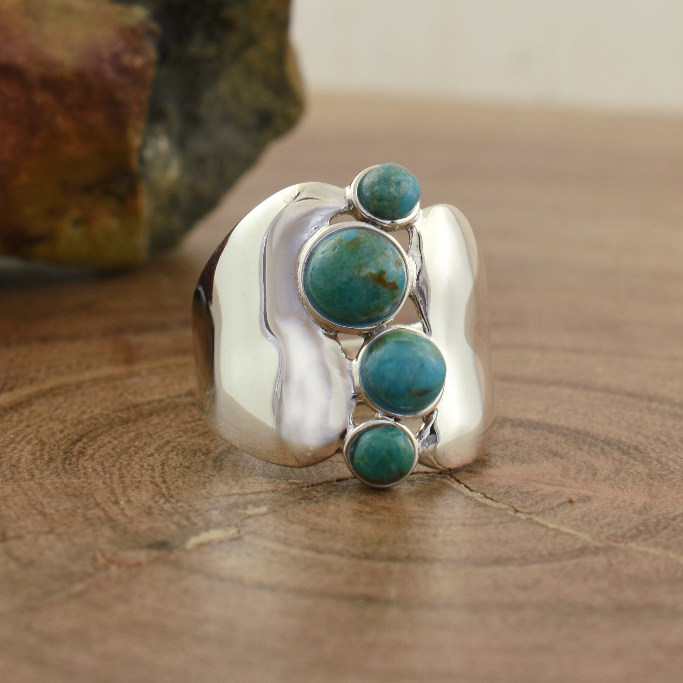 .925 sterling silver featuring four bezel set reconstructed turquoise stones