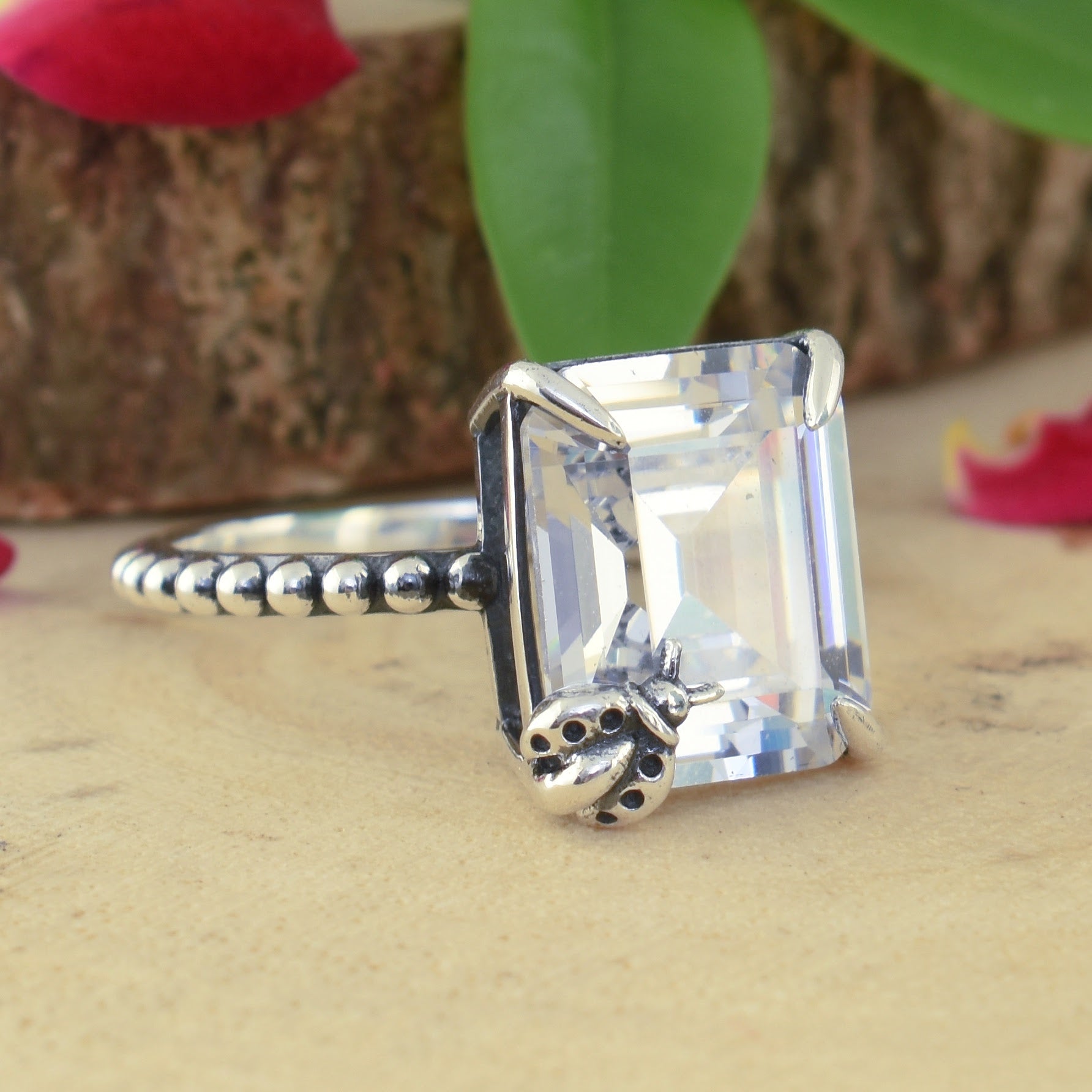 .925 sterling silver ring with emerald cut cz and ladybug prong